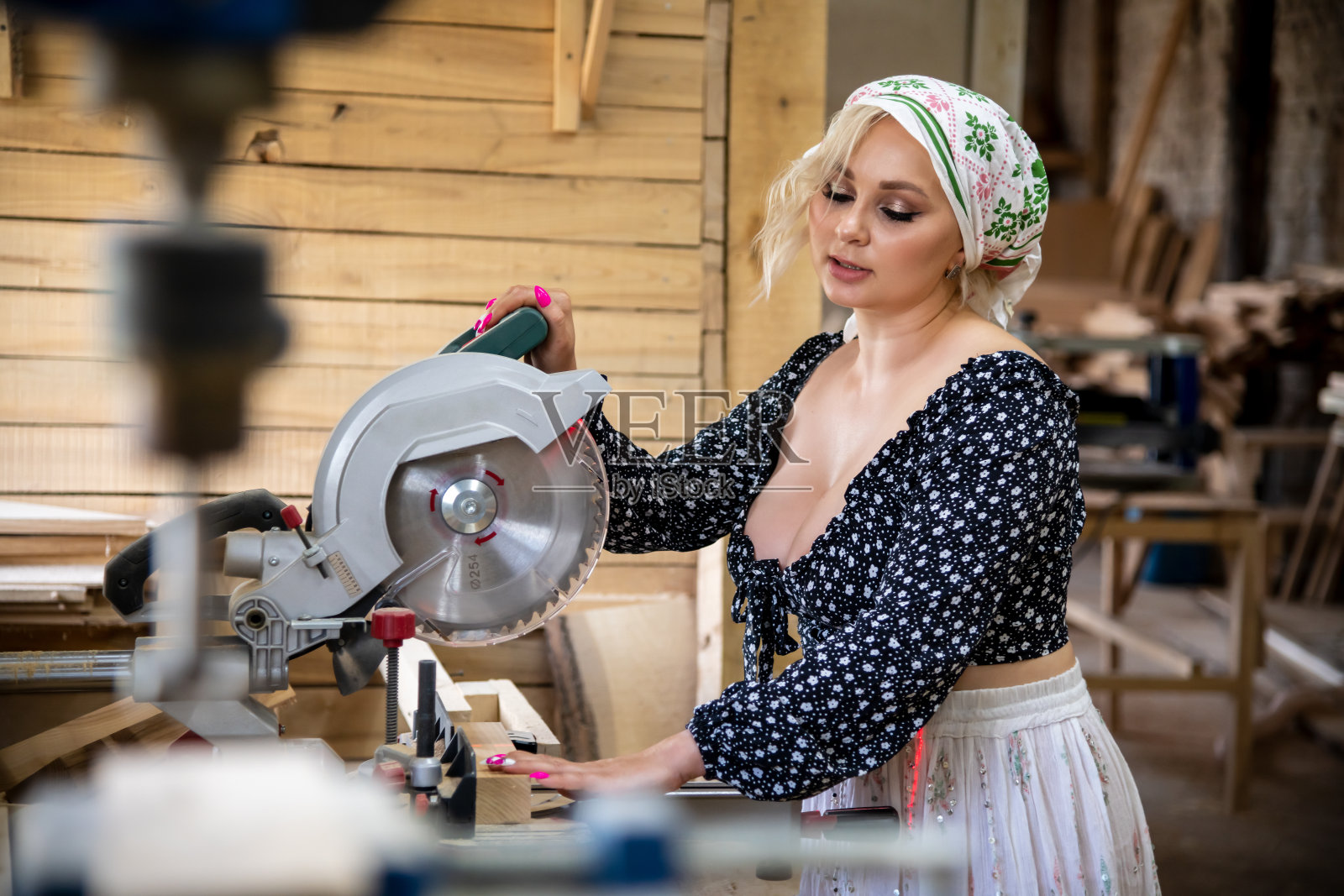 性感女人站在圆锯旁照片摄影图片