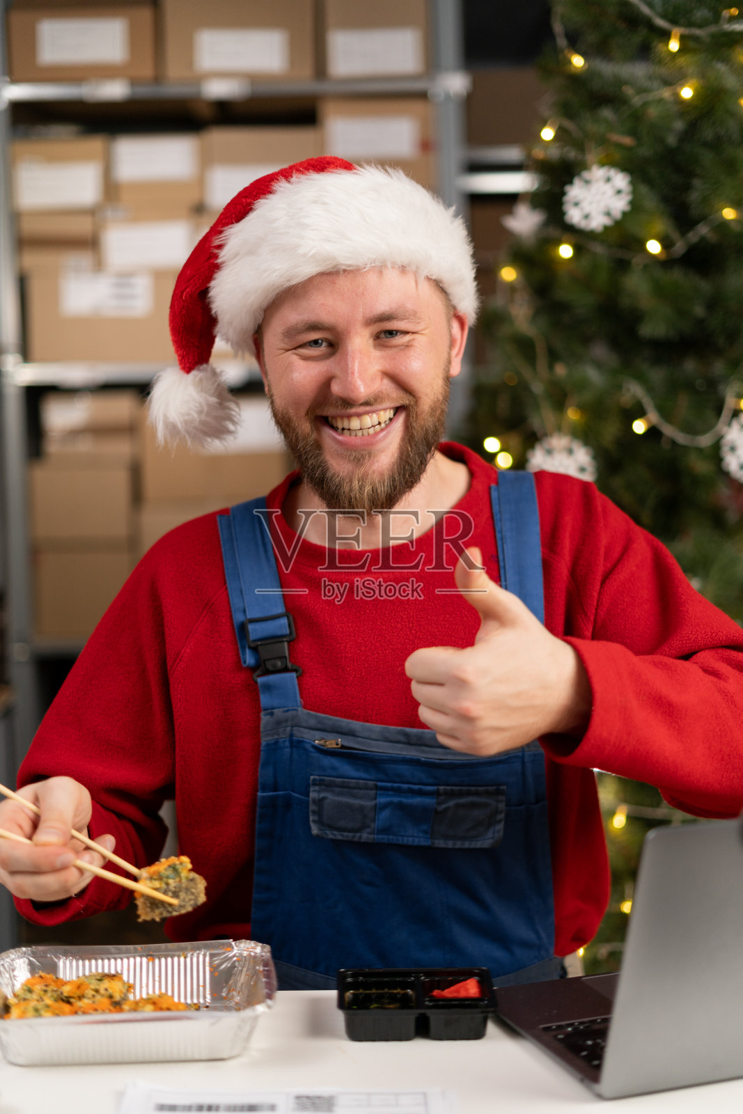 图为快乐的仓库工人在午餐休息时吃着寿司，竖起大拇指照片摄影图片