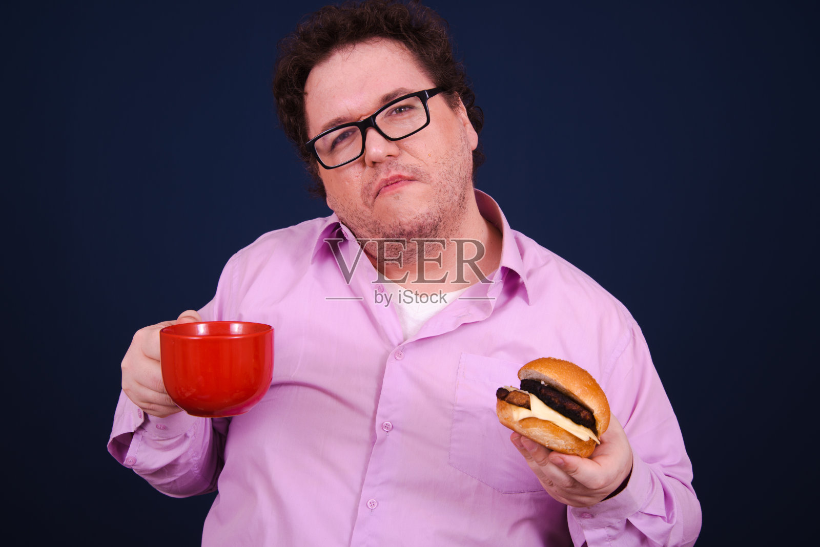 有趣的饥饿胖子吃汉堡。照片摄影图片