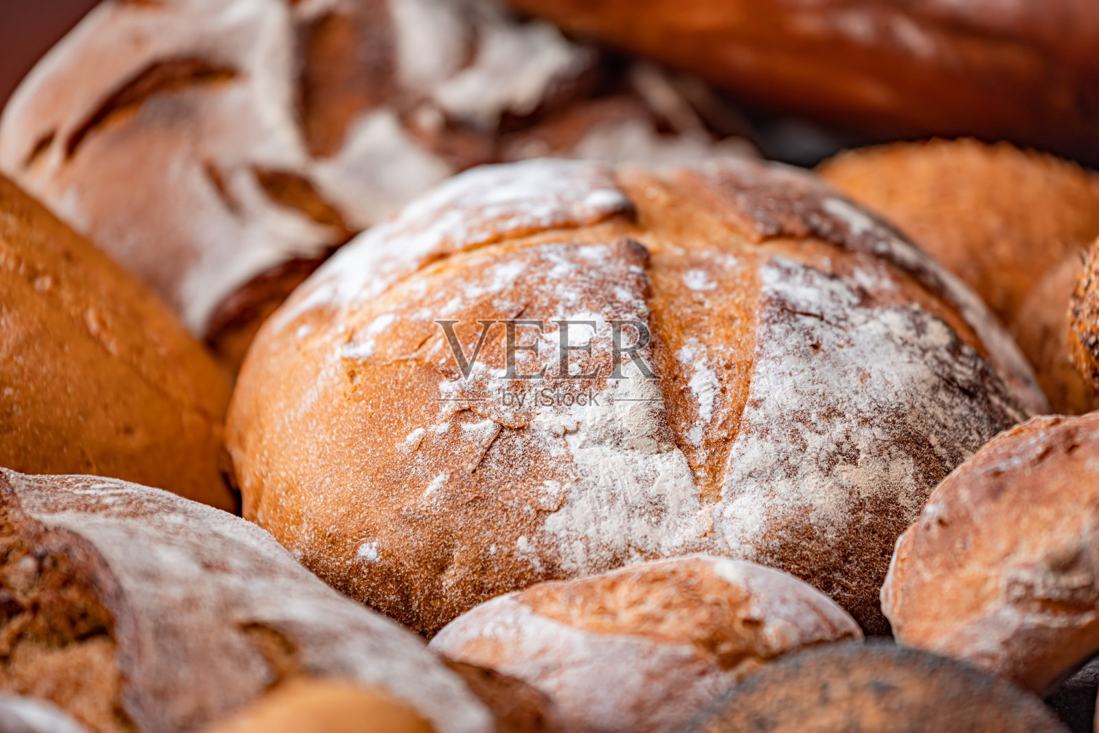 新鲜出炉的天然面包放在厨房的桌子上。照片摄影图片