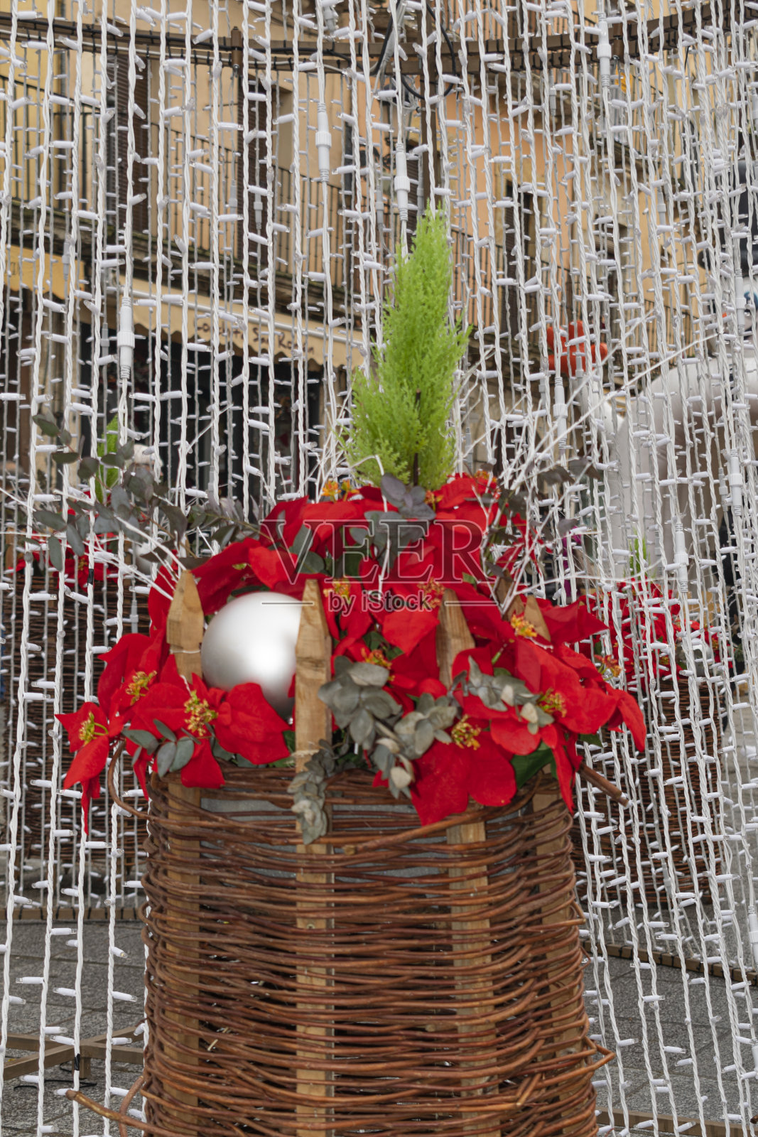 装满红色复活节花的柳条篮子装饰着街道——西班牙照片摄影图片