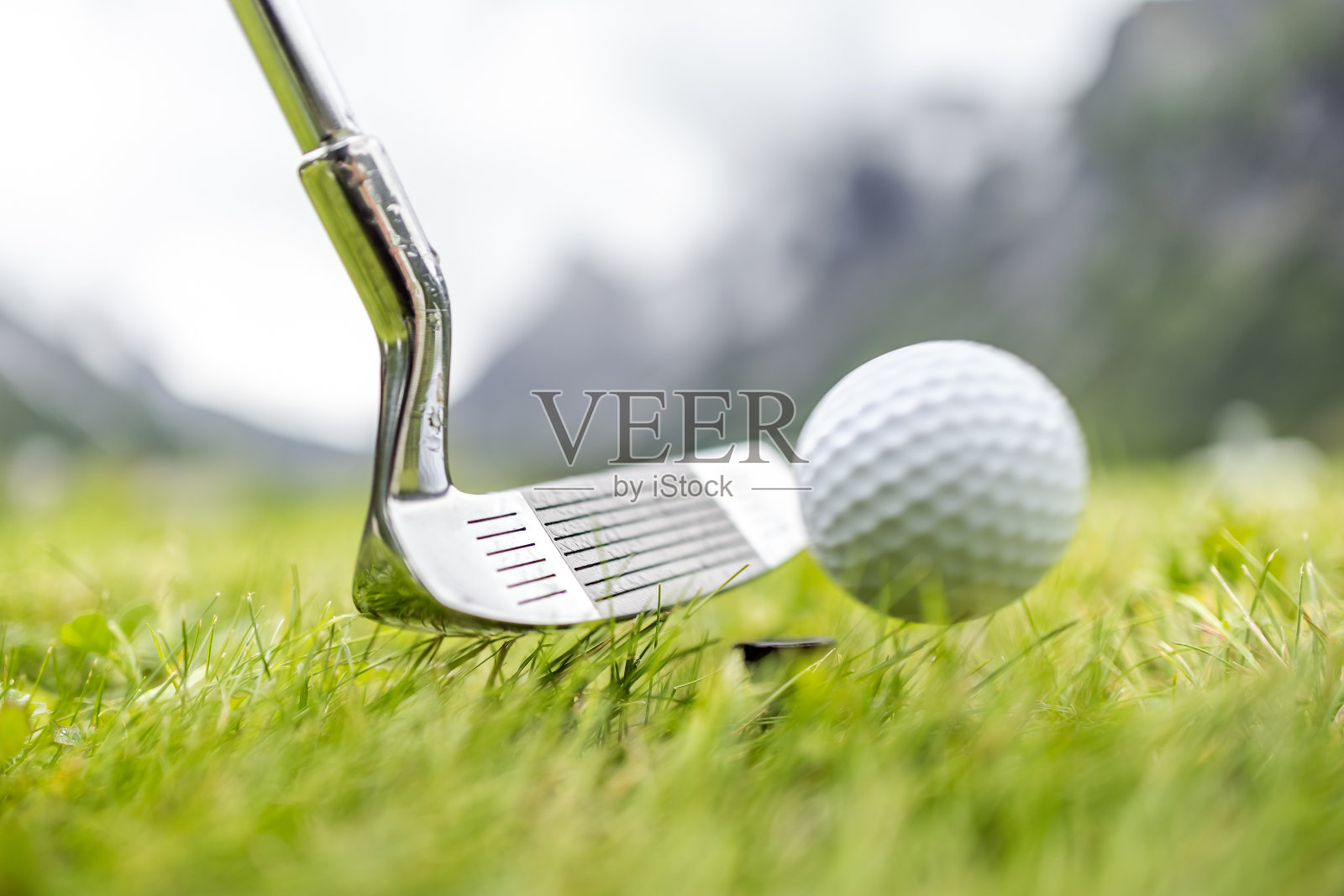 高尔夫球在司机前面的球座上照片摄影图片