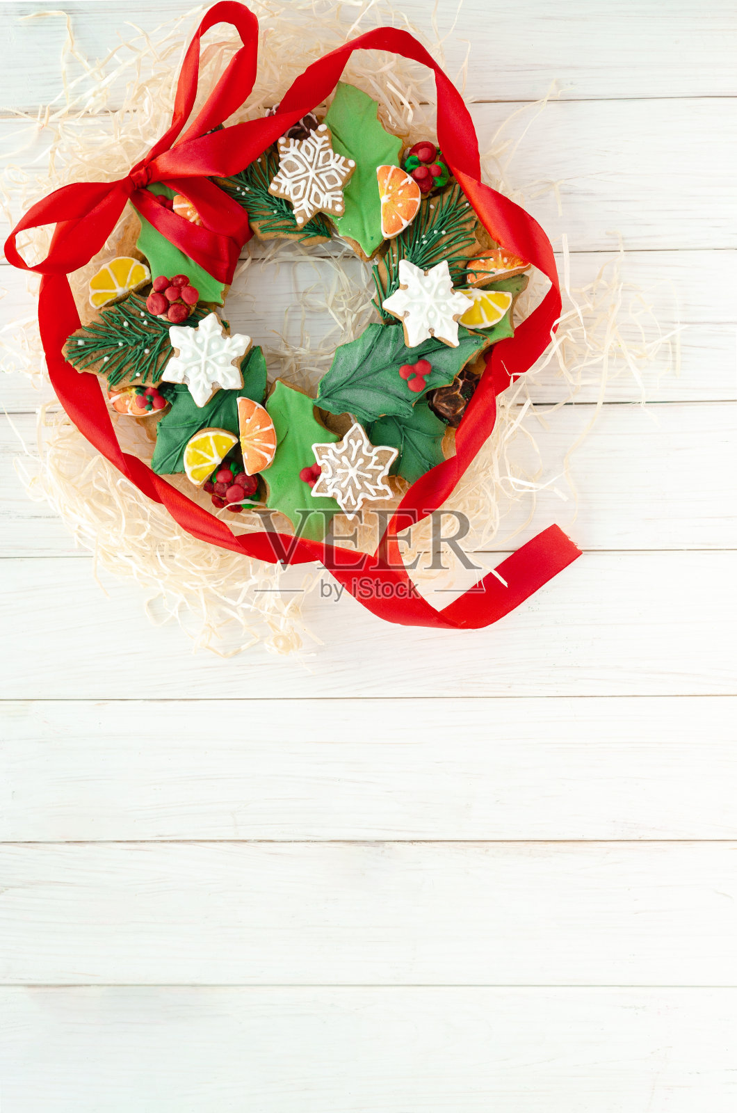 圣诞姜饼在圣诞花环的形式躺在一个白色的木制背景。圣诞贺卡照片摄影图片