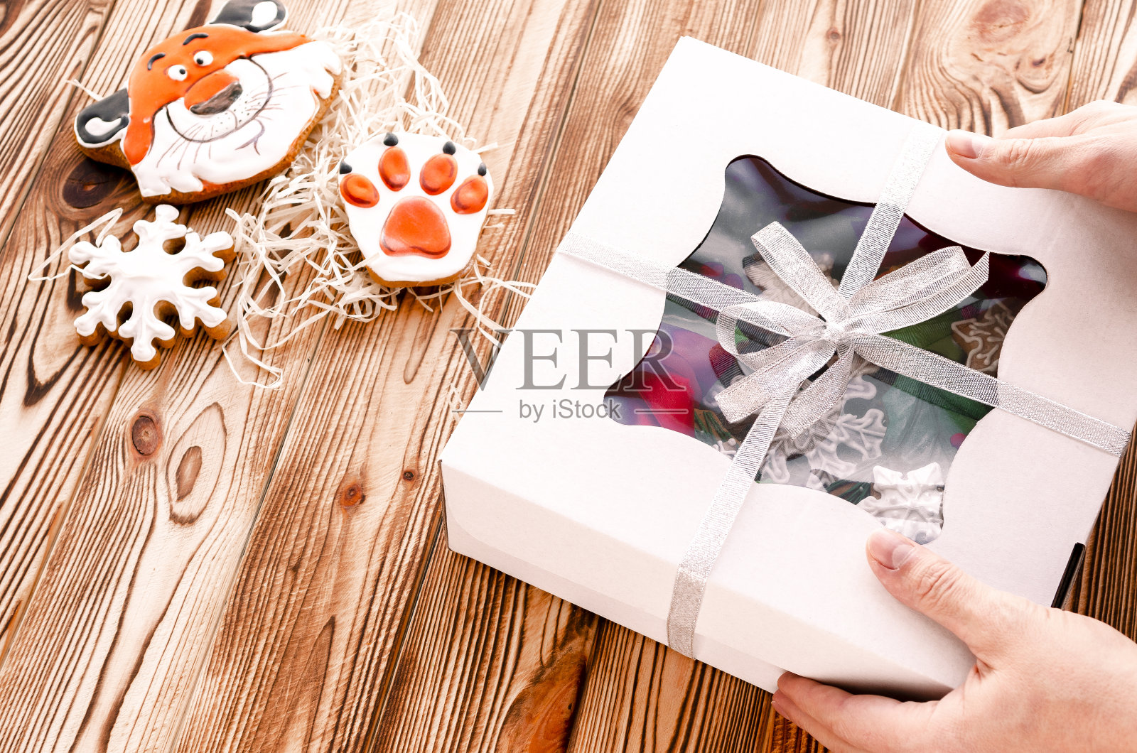 一个木制背景的男人手里拿着圣诞礼物照片摄影图片