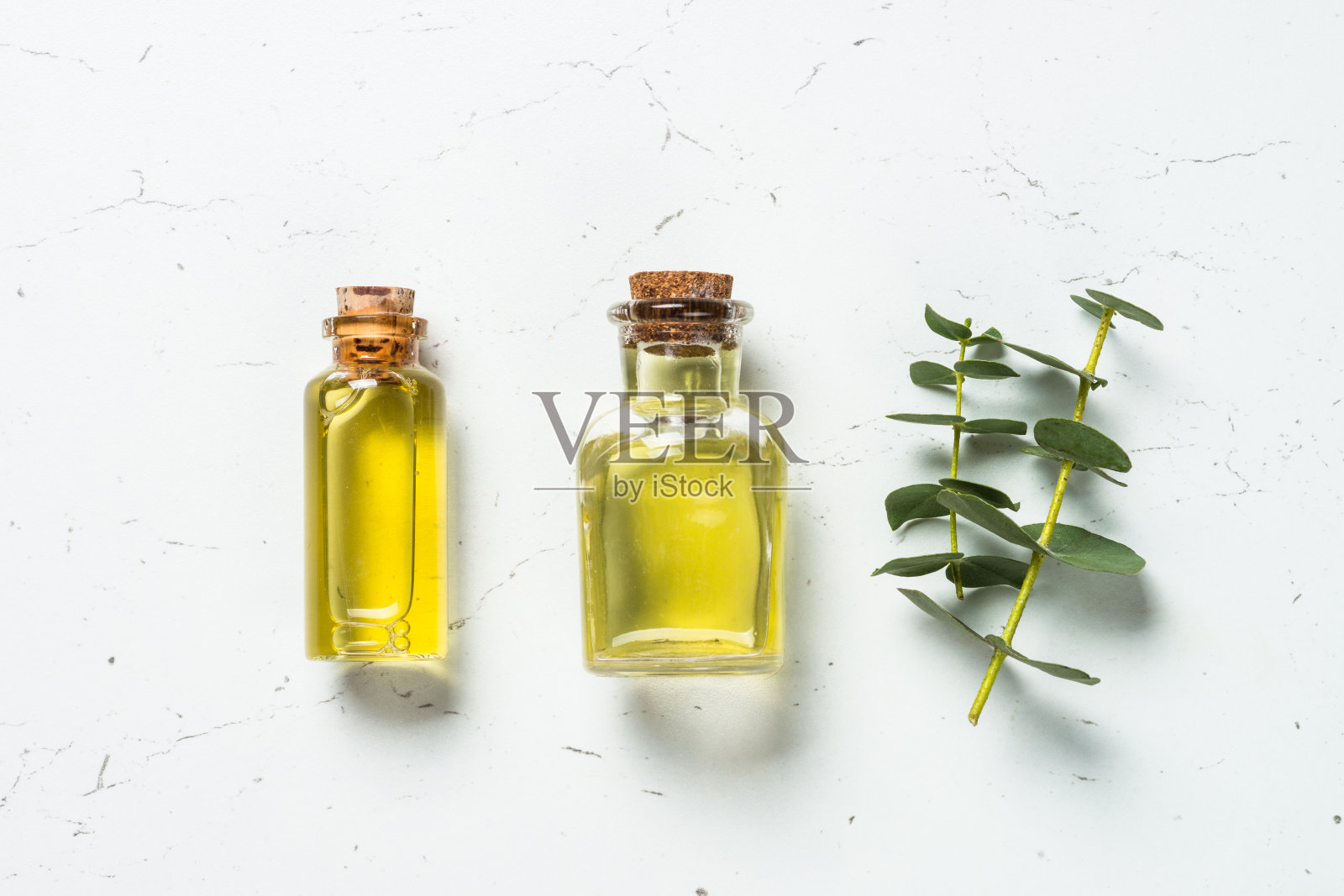 桉树油在玻璃瓶和绿色桉树叶子。照片摄影图片