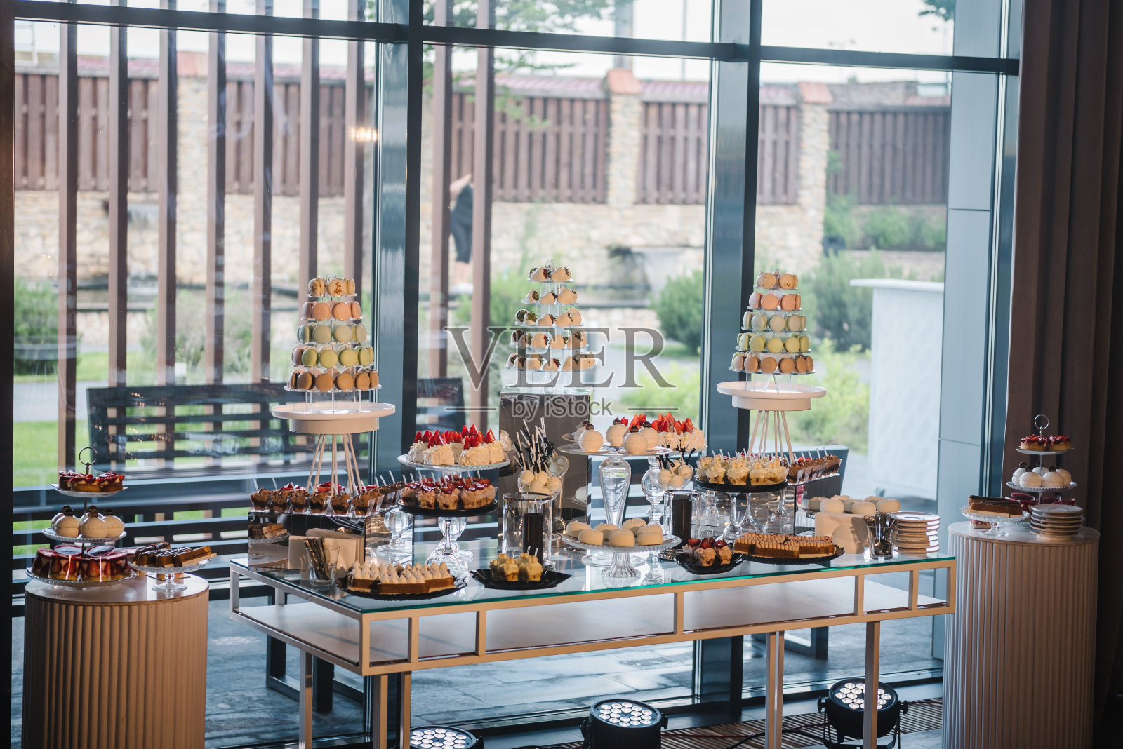 婚宴上的糖果棒特写。蛋白杏仁饼干。美味的接待奢华的仪式。桌上摆满了糖果、糖果和甜点。盘中美味的彩色法式马卡龙。烹饪和烹饪概念。照片摄影图片