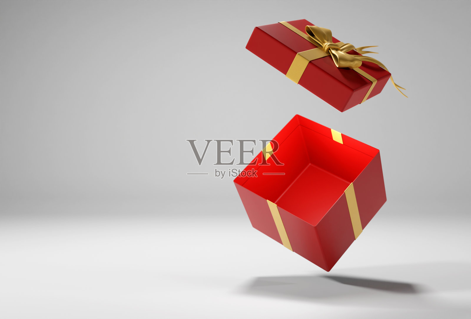 打开红色礼盒与金色丝带和蝴蝶结在白色背景与阴影照片摄影图片