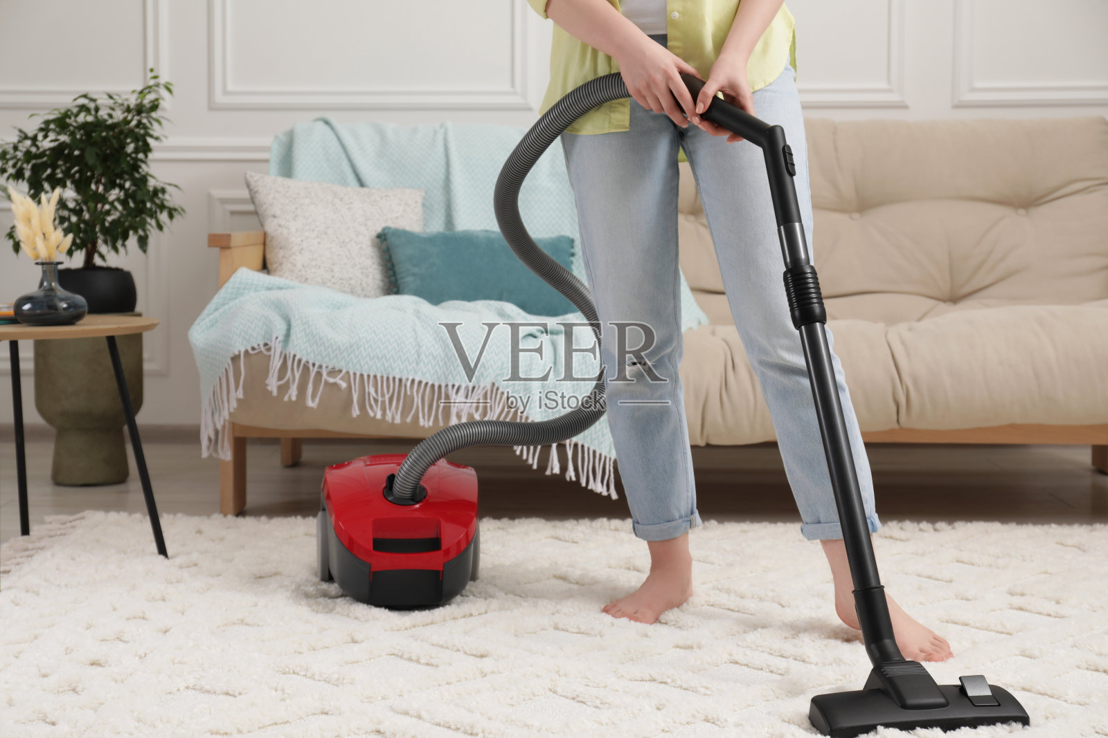 妇女在家里用吸尘器清洁地毯，特写。文本空间照片摄影图片