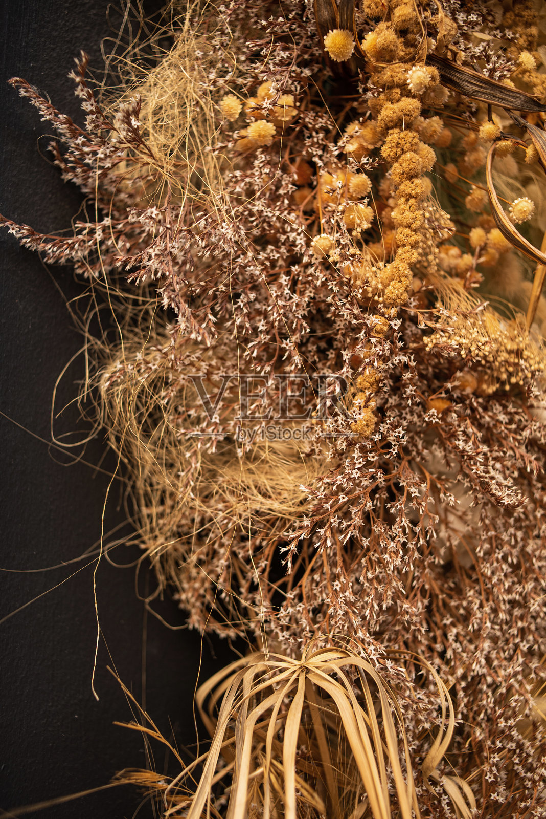 墙上的干花装饰。一束干花。在波西米亚风格的花卉简约家居室内。波西米亚风格的节日拍照区装饰。照片摄影图片