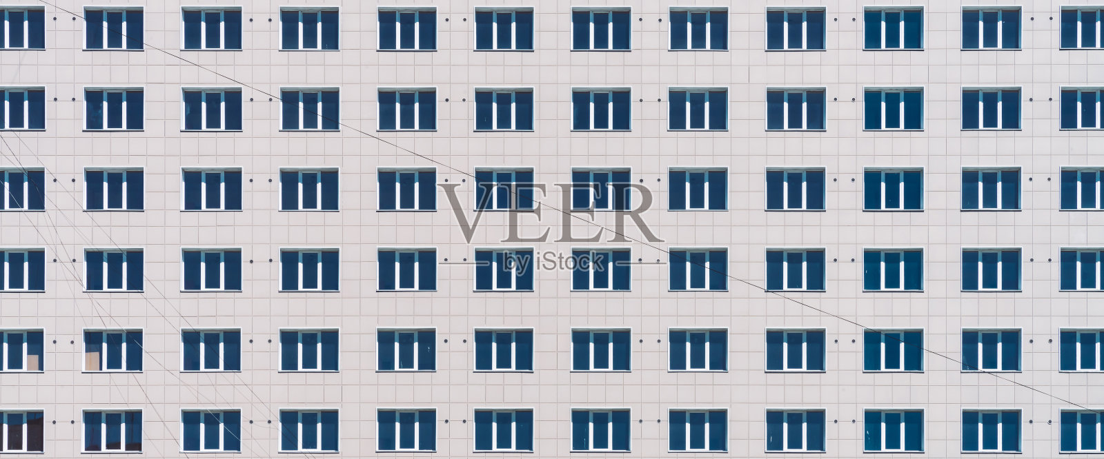 几何背景与许多窗口行。简约经典设计的高层建筑。办公楼的现实概念。公寓房子纹理背景。许多窗户在大墙上特写。照片摄影图片