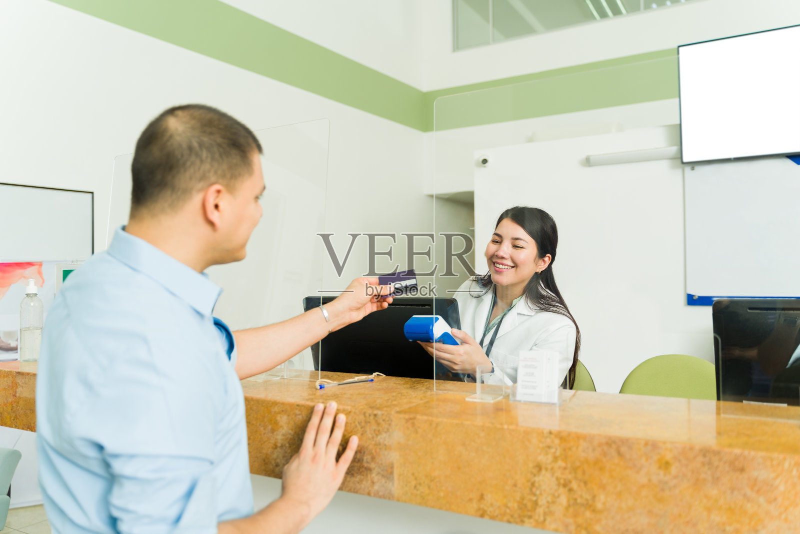 开心的病人用信用卡支付化验费用照片摄影图片