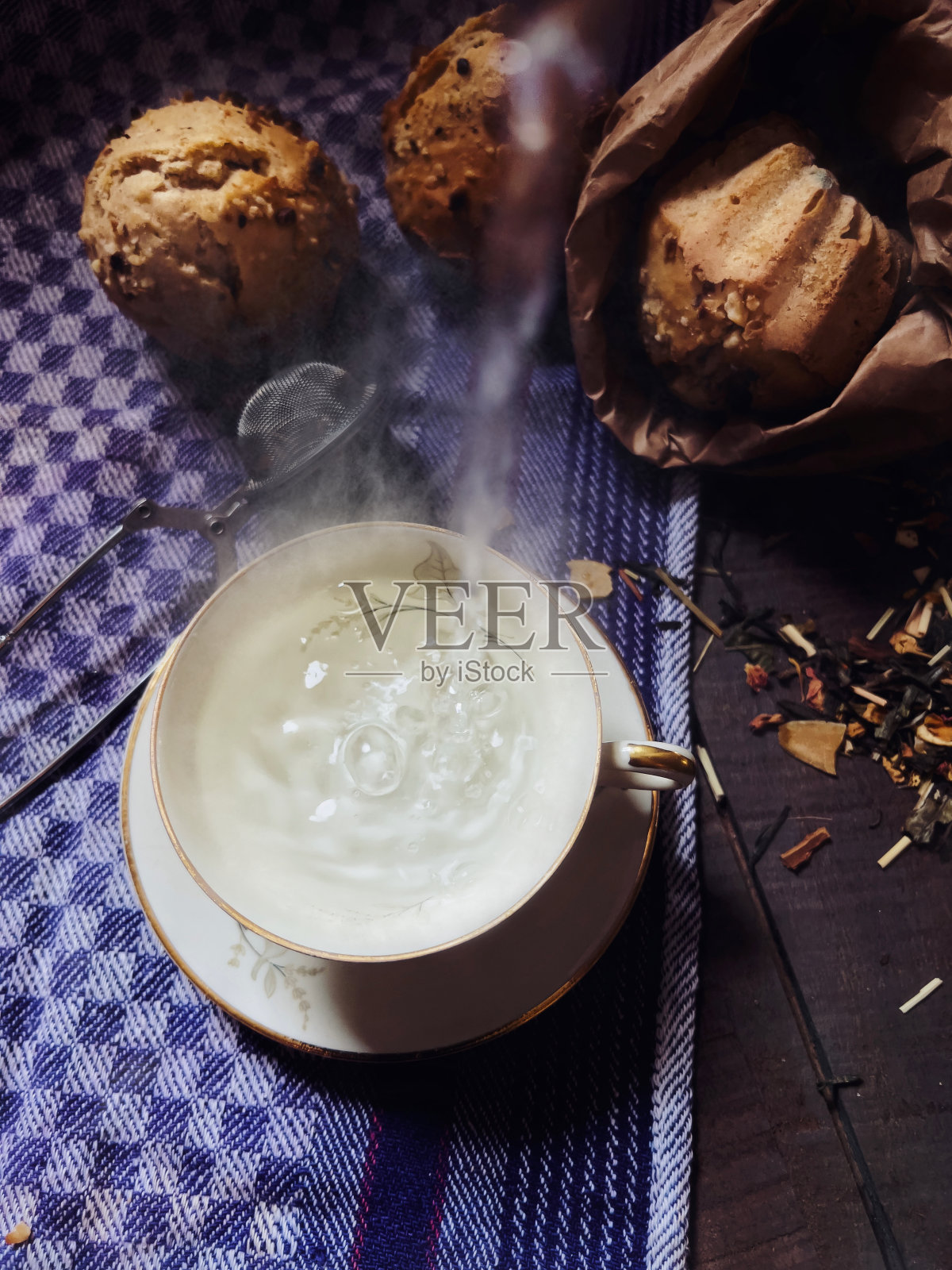 正上方的格子布上拍摄了滚烫的热水倒入茶杯的特写照片摄影图片