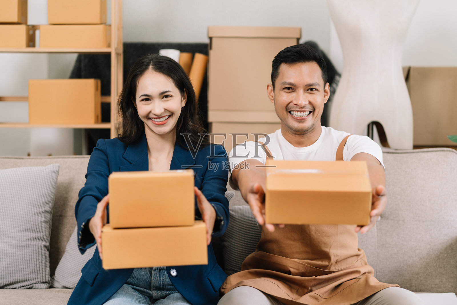 肖像年轻迷人的亚洲夫妇老板创业工作快乐的盒子在家里准备包裹递送在中小企业供应链，启动小企业的概念。照片摄影图片