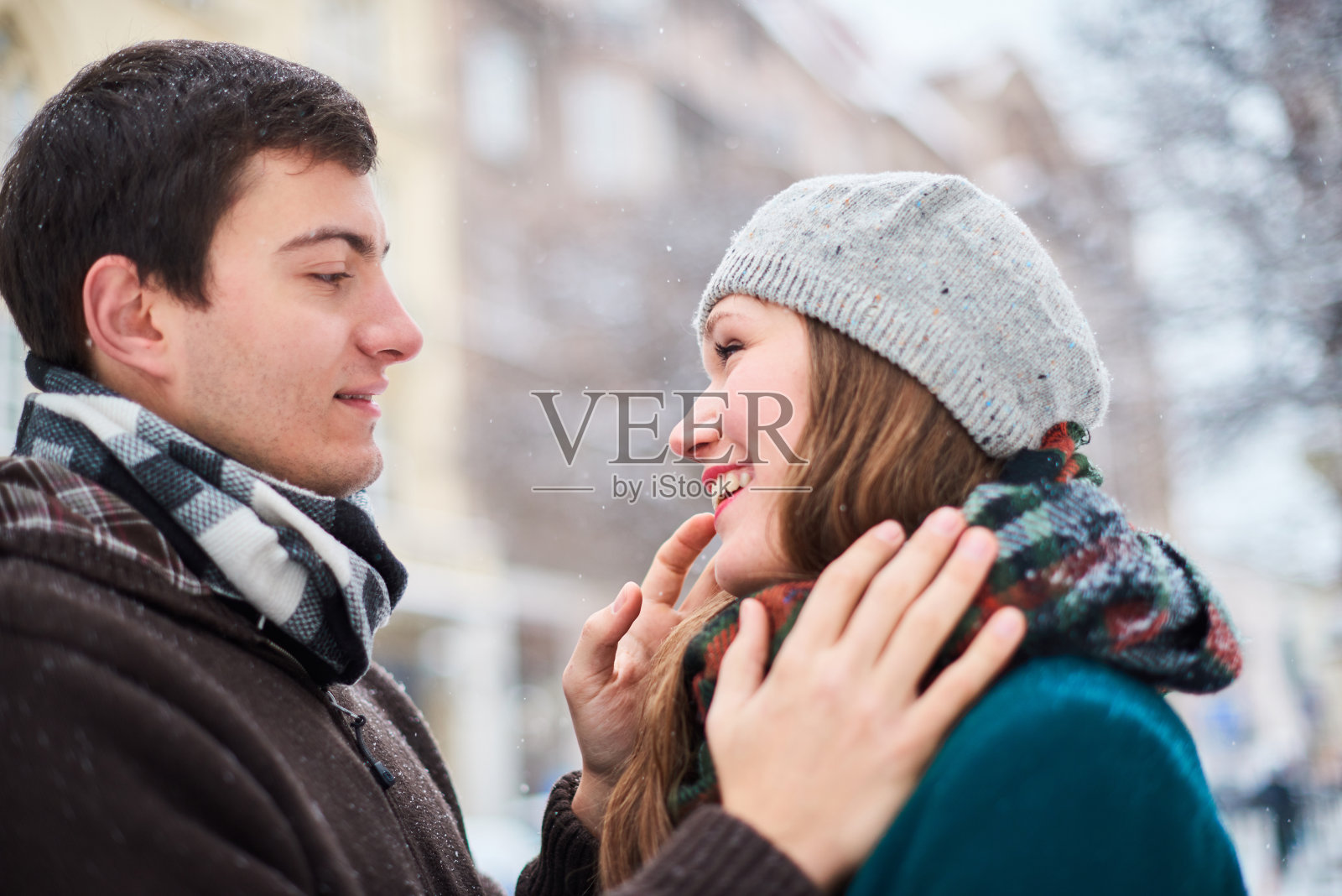 一对戴着格子围巾的年轻情侣在冬天漫步在老城照片摄影图片
