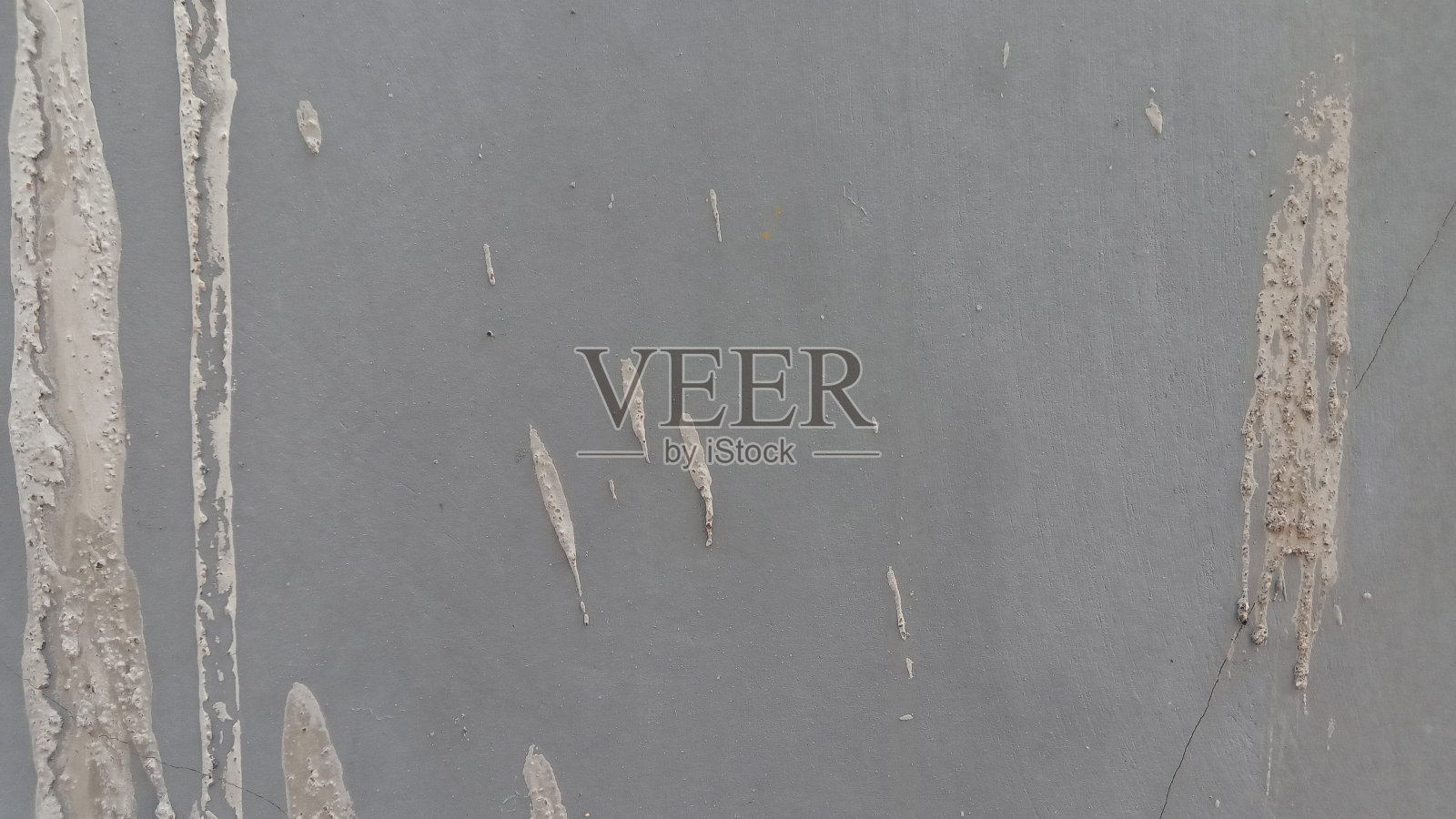 背景是一堵灰墙，上面溅着水泥照片摄影图片