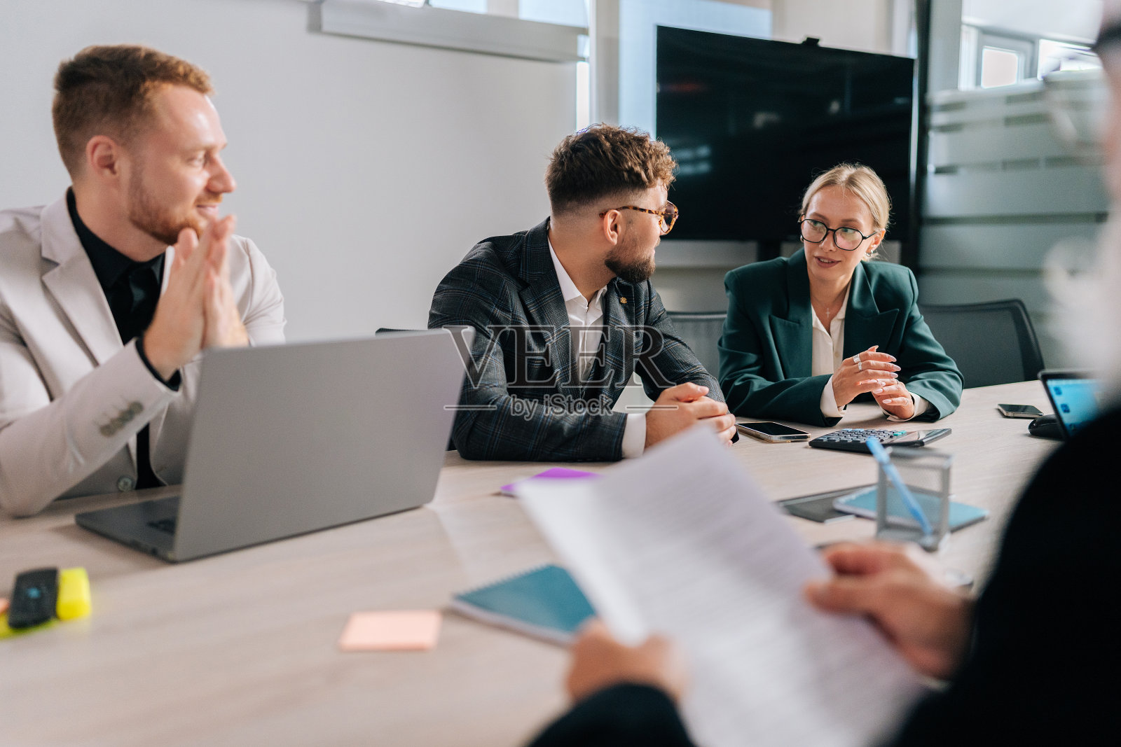 成功的年轻商业团队在公司会议期间对项目进行头脑风暴。男女员工分组倾听同事分享想法照片摄影图片