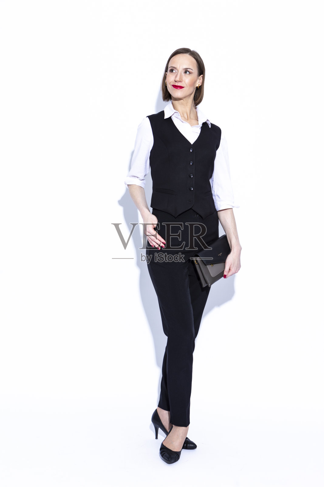 业务概念。积极自信的白人商务女性肖像，穿着白衬衫，拿着白色的手包照片摄影图片