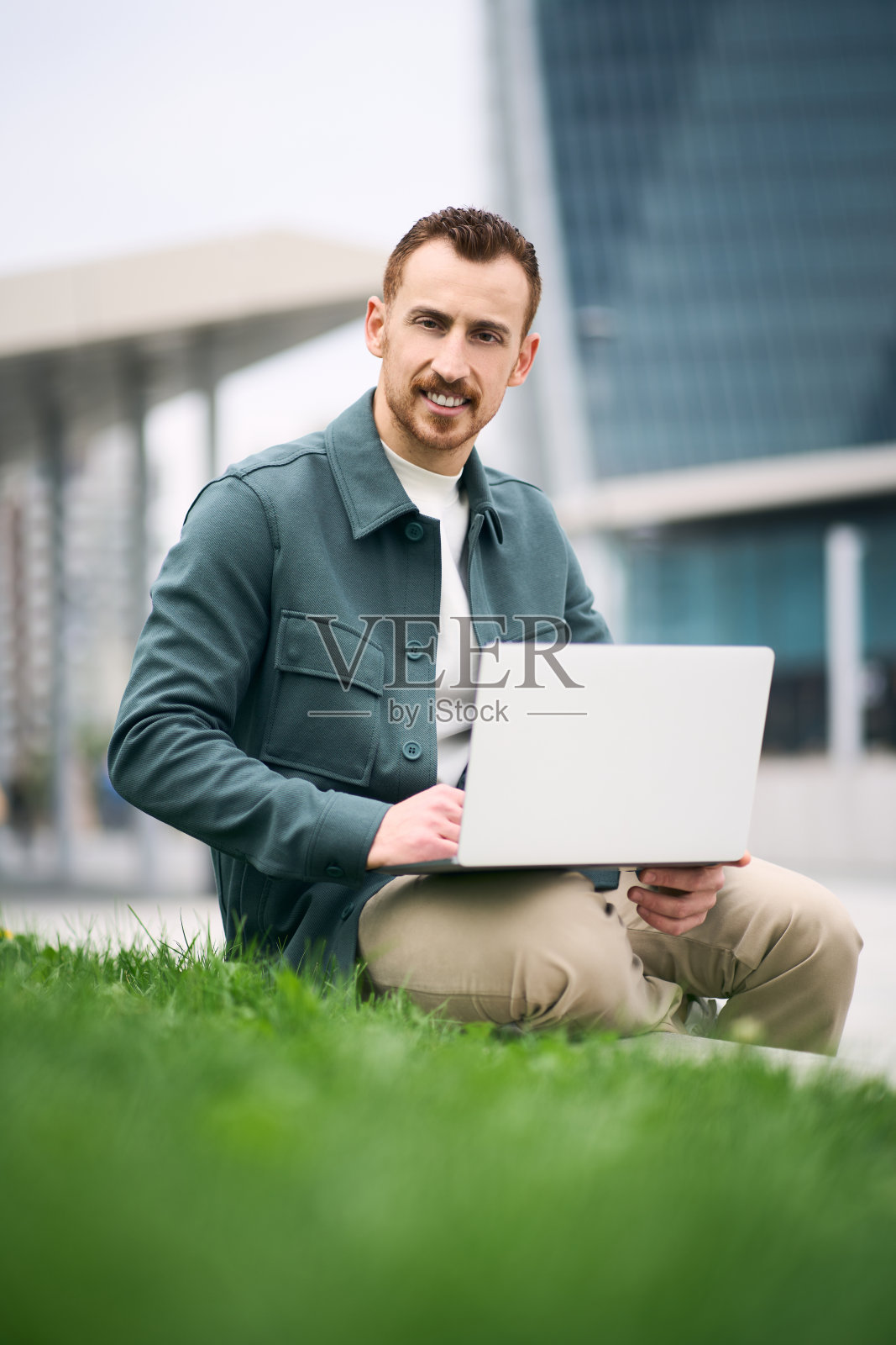 年轻有魅力的商人在街上上网看相机工作笔记本电脑照片摄影图片