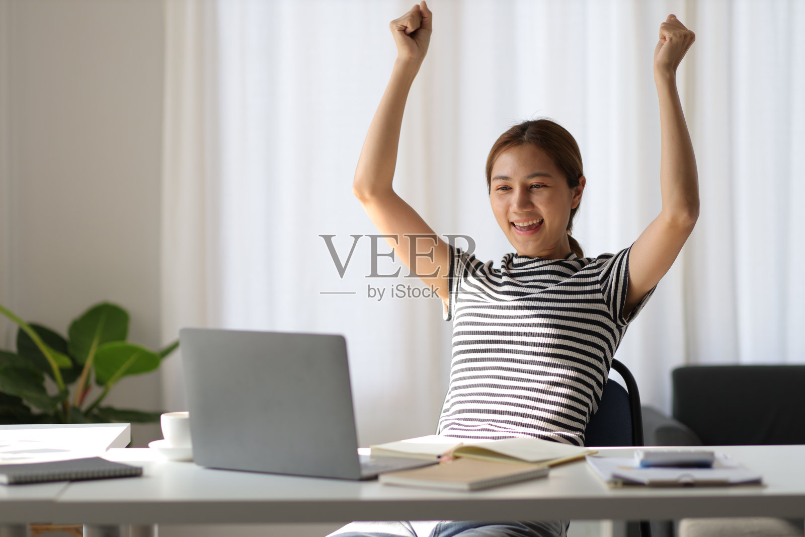 兴奋和快乐的女人在使用笔记本电脑。照片摄影图片