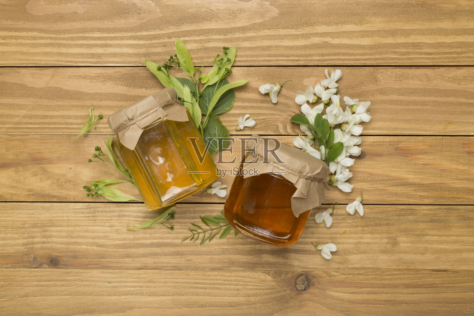 木制背景上装有不同种类蜂蜜的罐子，俯视图照片摄影图片