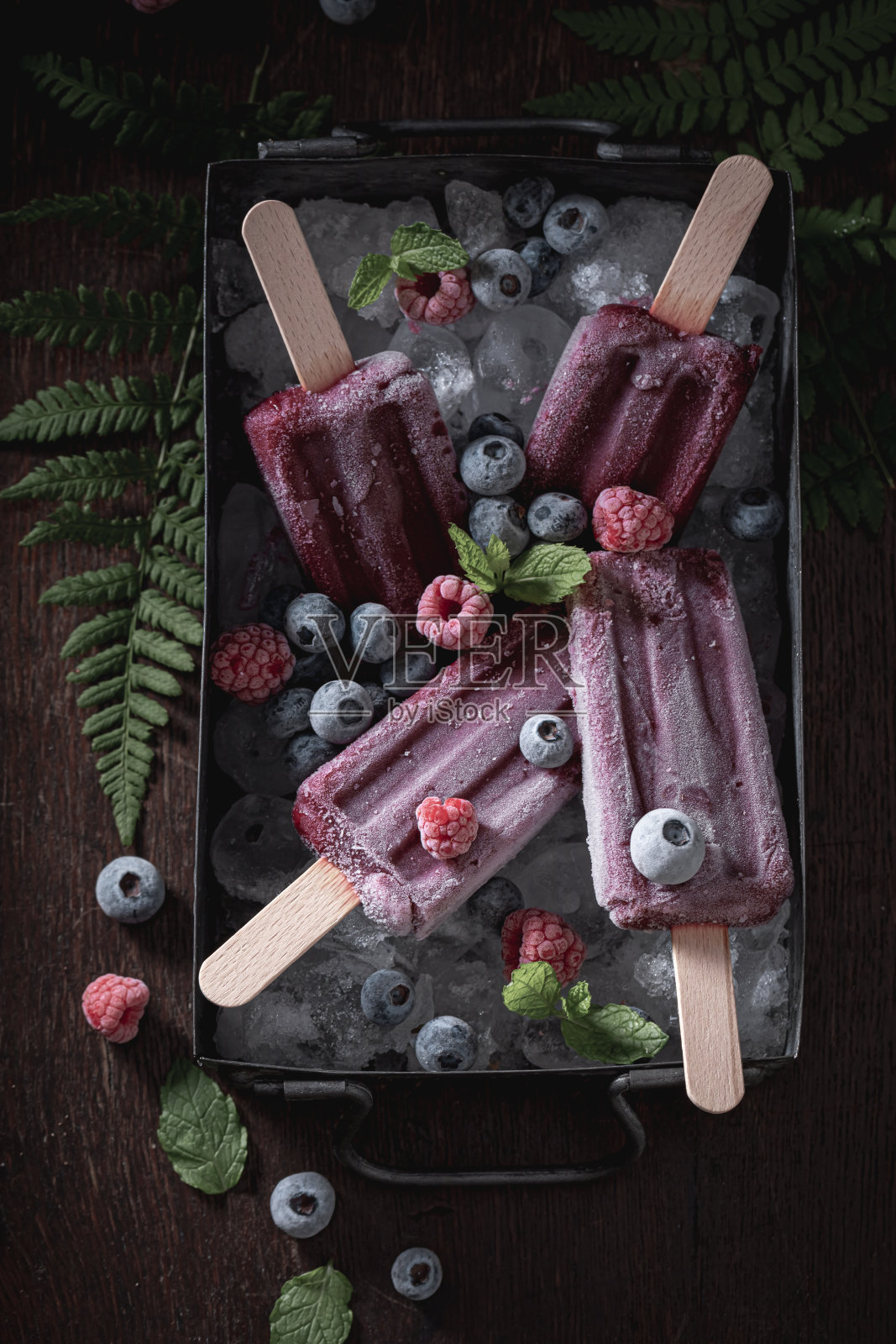 由蓝莓和覆盆子制成的冰激淋冰糕。照片摄影图片