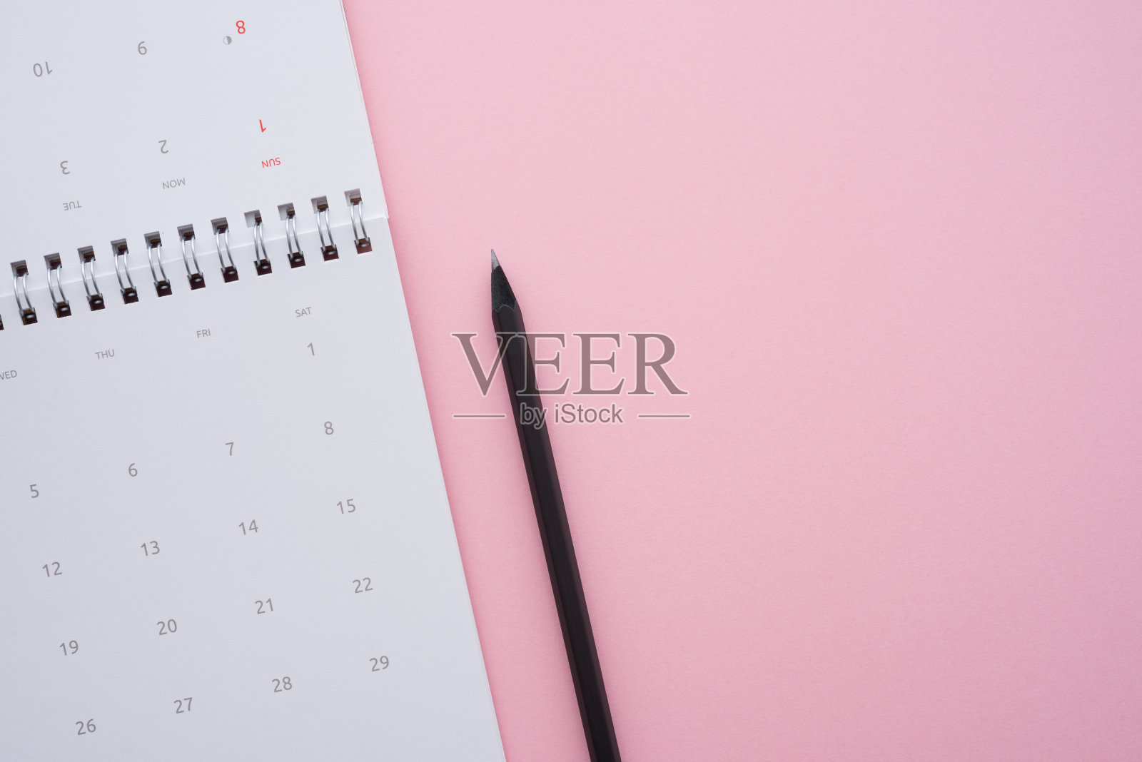 粉红色背景上的铅笔的白色空的干净的日历平铺。照片摄影图片