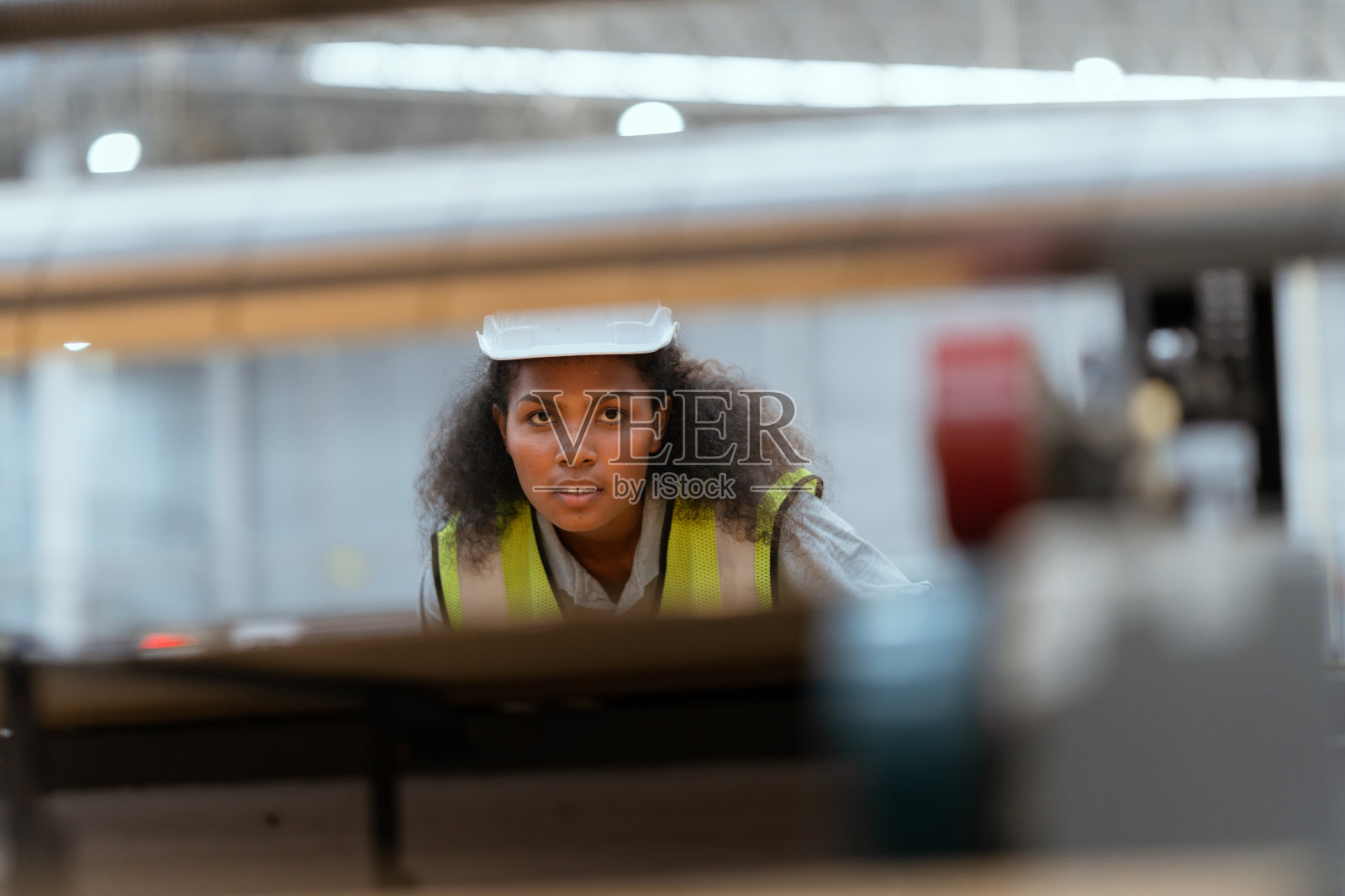 一名女员工正在仓库里使用机器缝制纸板箱。照片摄影图片