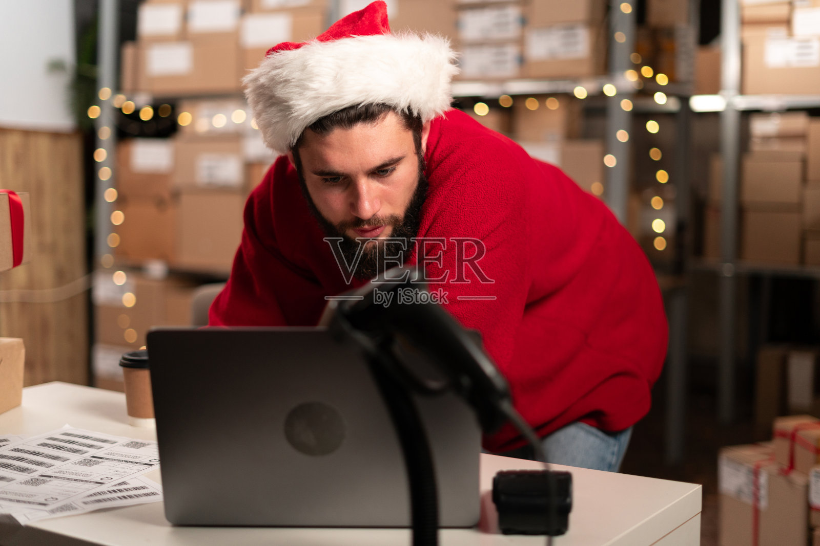 库存经理在仓库使用笔记本电脑，准备纸板箱邮资。在仓库工作，完成订单照片摄影图片