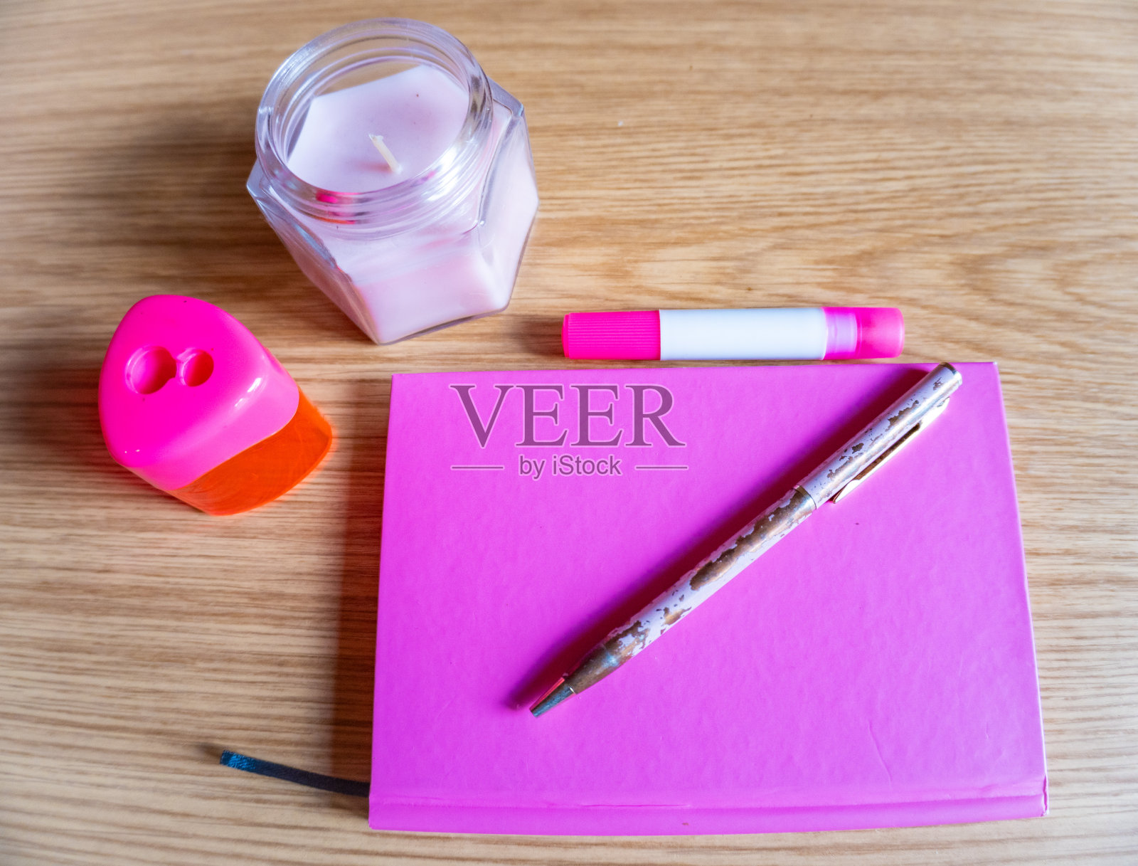 梳妆台上的笔记本、钢笔、蜡烛都是粉红色的照片摄影图片