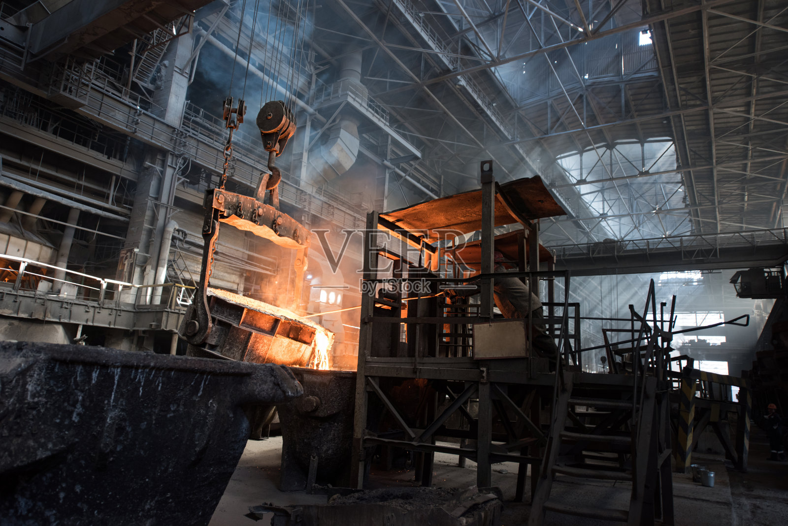 在储罐附近工作的钢铁工人正在处理热金属照片摄影图片