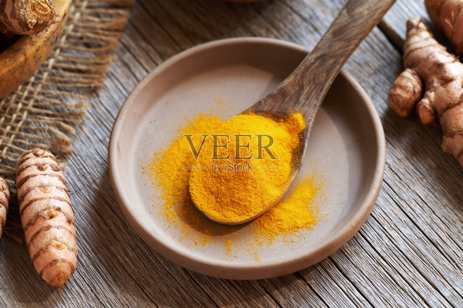 姜黄粉和新鲜根放在桌子上照片摄影图片