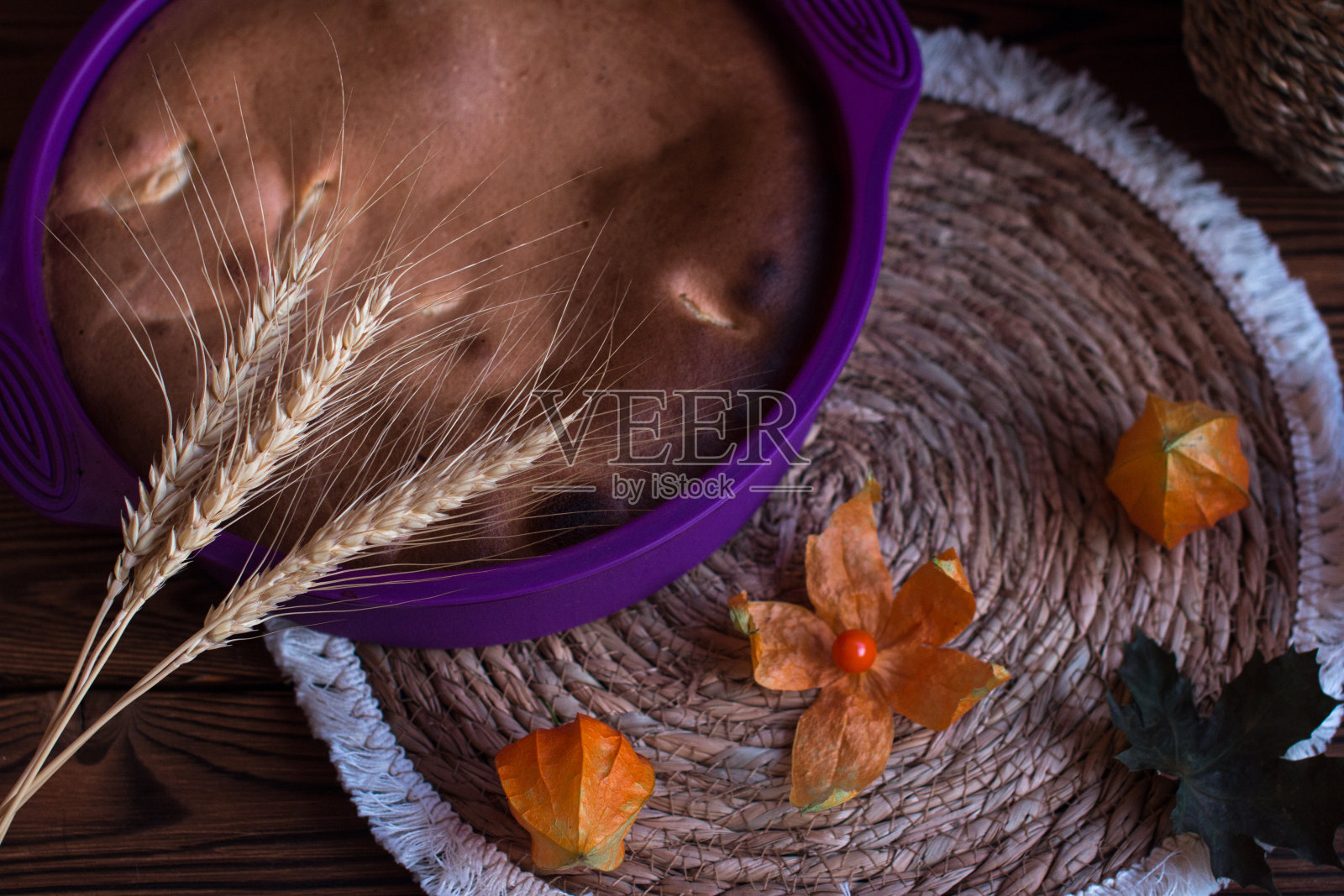 一个煮熟的苹果派，木制背景上装饰着physalis花，黑莓和蔓越莓。苹果夏洛特照片摄影图片