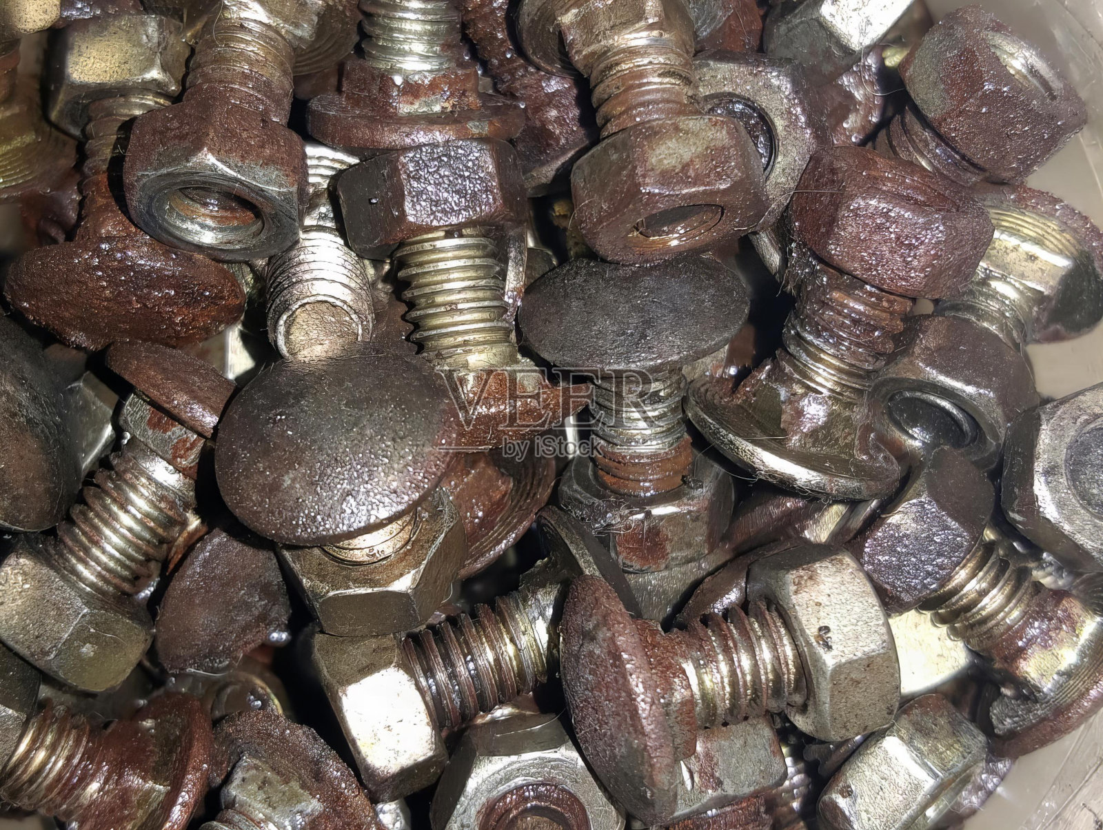 一个装满螺母和螺栓的容器的照片，一个装满螺母和螺栓的容器的特写。照片摄影图片