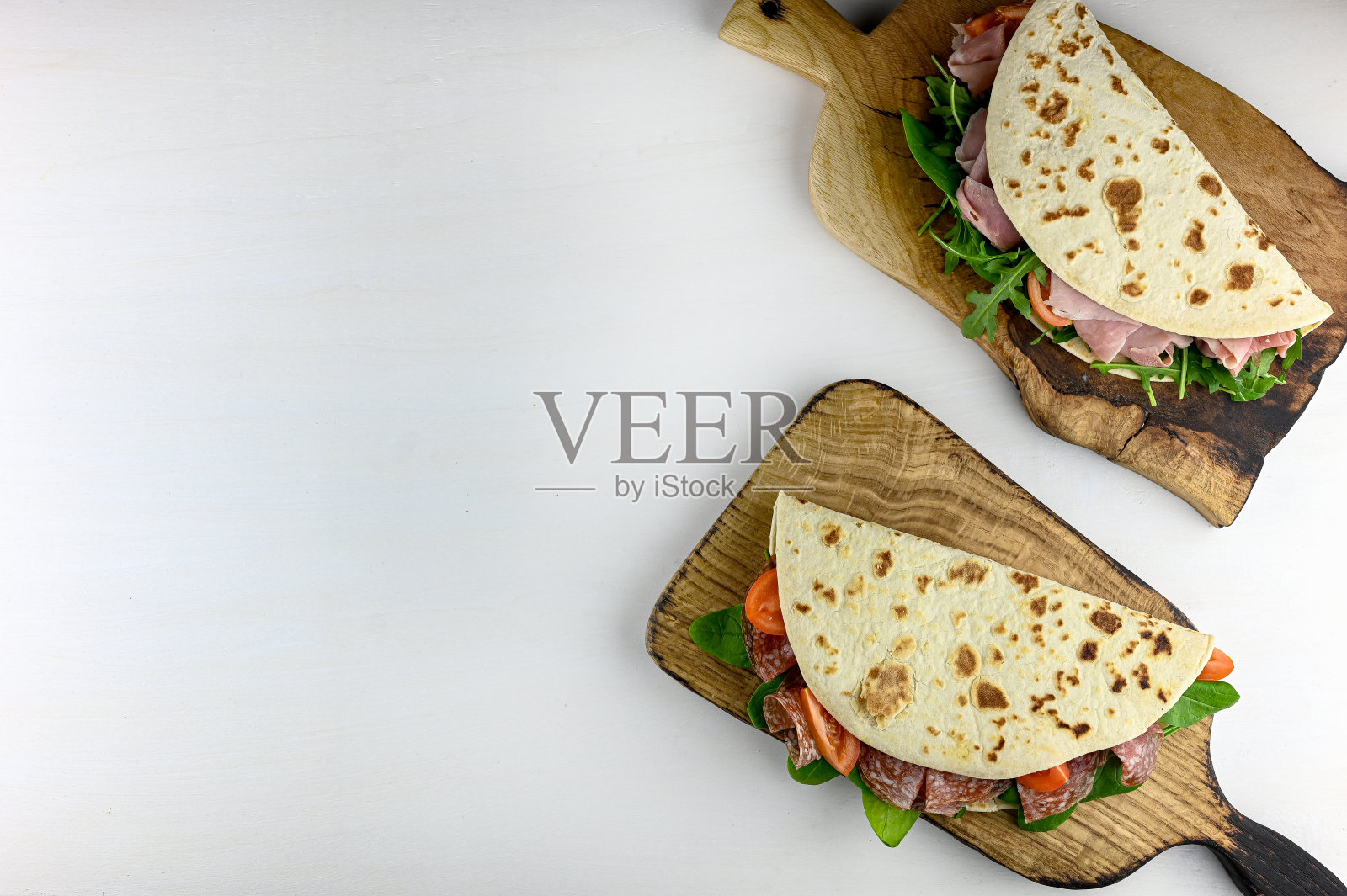 白色的桌子上放着美味的火腿馅饼。照片摄影图片