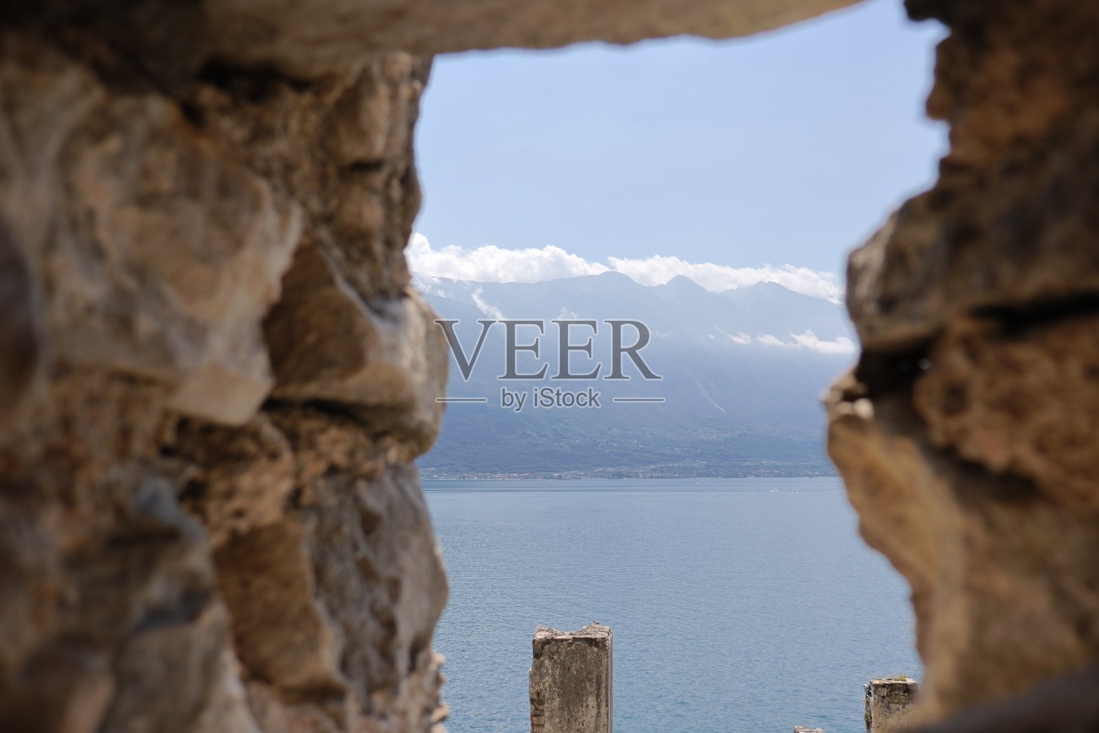 从古城墙的洞里看到的加尔达湖照片摄影图片