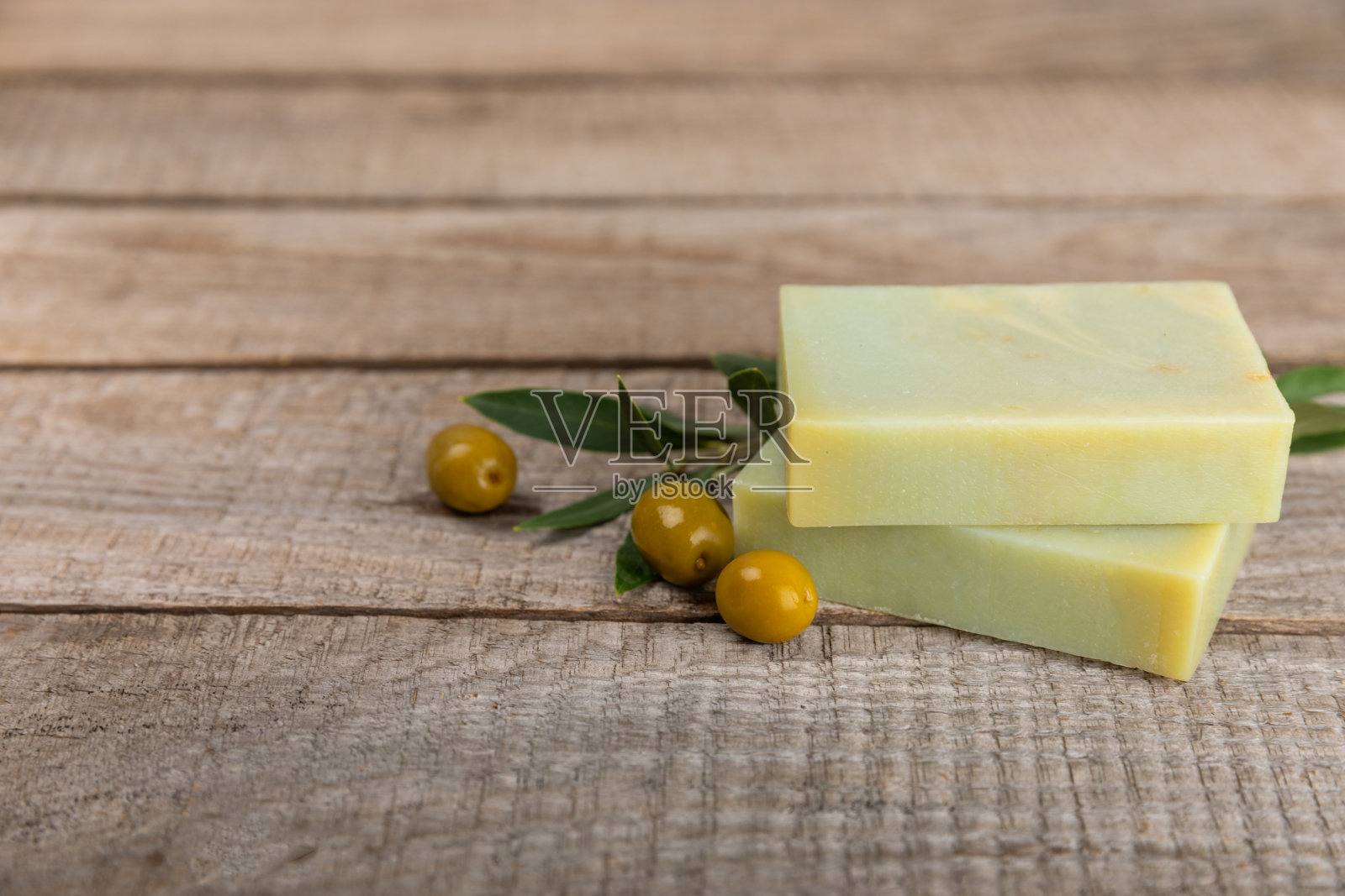 天然的温泉。橄榄天然肥皂和橄榄浆果纹理背景。天然美容成分的概念，温和的皮肤护理。自制橄榄油香皂。水疗护理。副本的空间。照片摄影图片