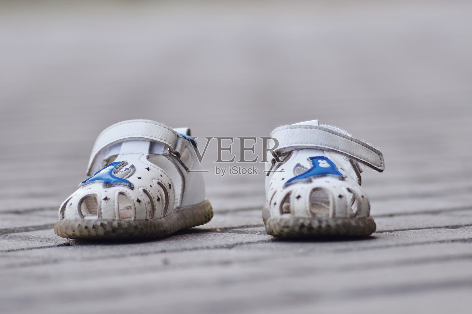 人行道上的一双白色凉鞋。有选择性的重点。照片摄影图片