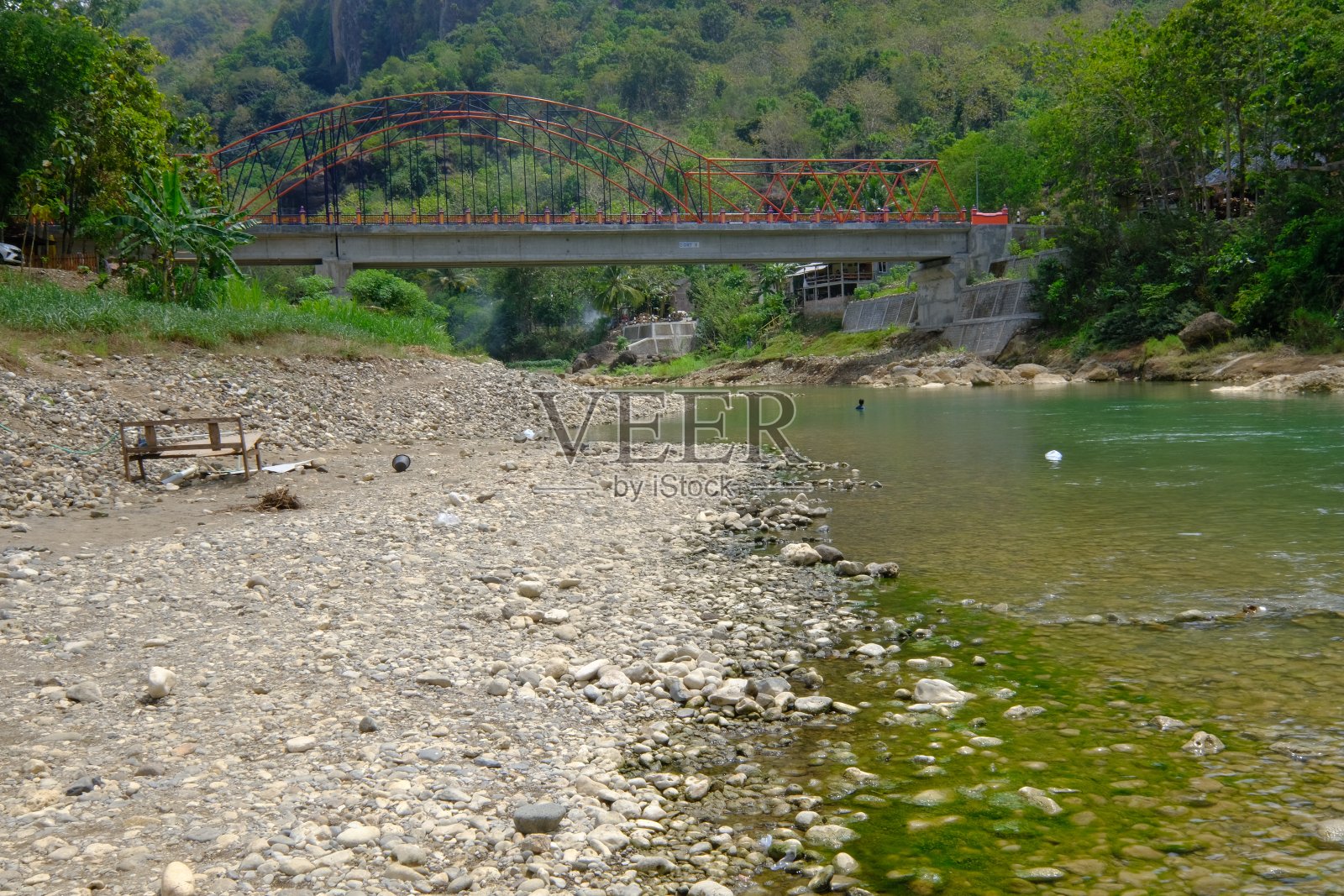 岩石河有清澈的水，河岸上有长满绿色苔藓的岩石。旱季热带地区的河岸。照片摄影图片