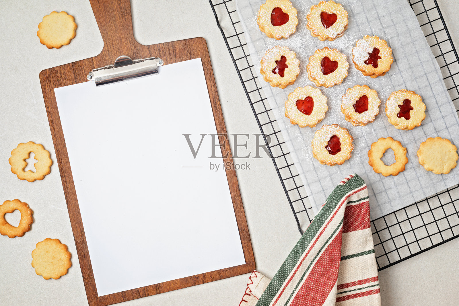 传统的自制林兹或三明治圣诞饼干填充覆盆子果酱和剪贴板的食谱模型。圣诞烘焙点子照片摄影图片