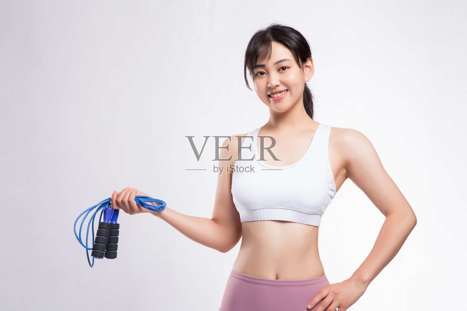 女子在灰色背景前准备跳绳训练照片摄影图片