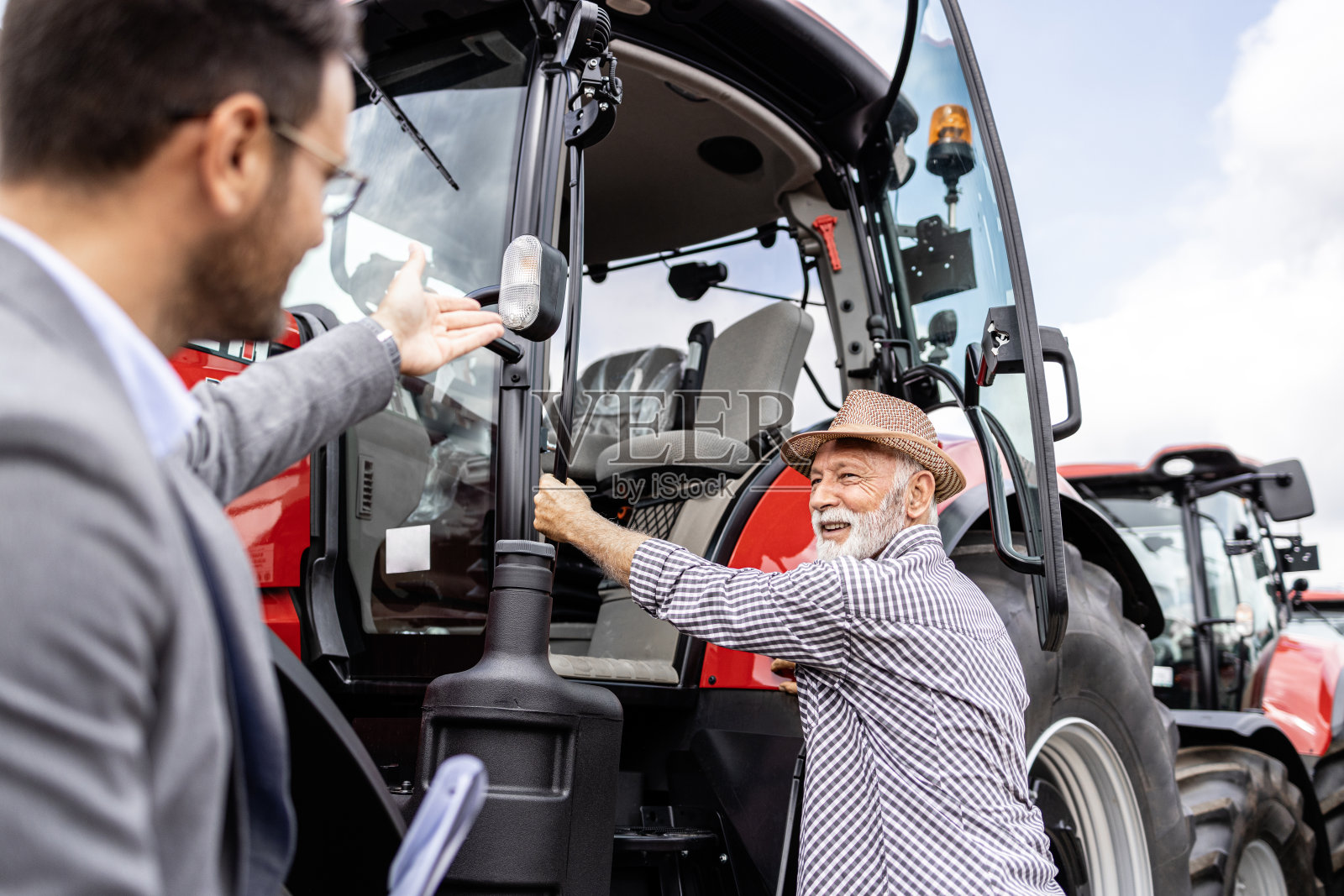 拖拉机经销商。农民测试新拖拉机。照片摄影图片