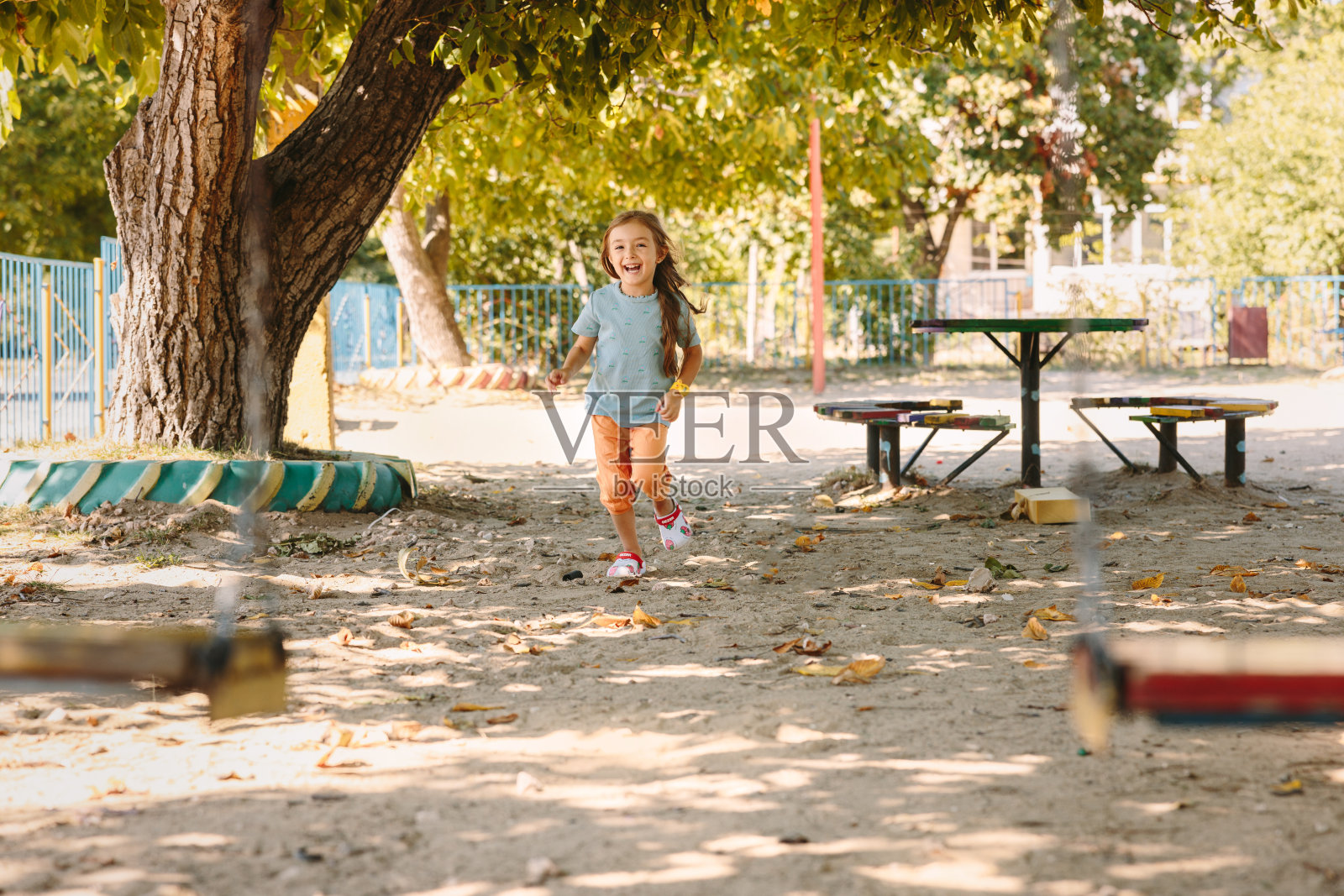 一个白人小女孩很高兴，跑到她最喜欢的操场照片摄影图片