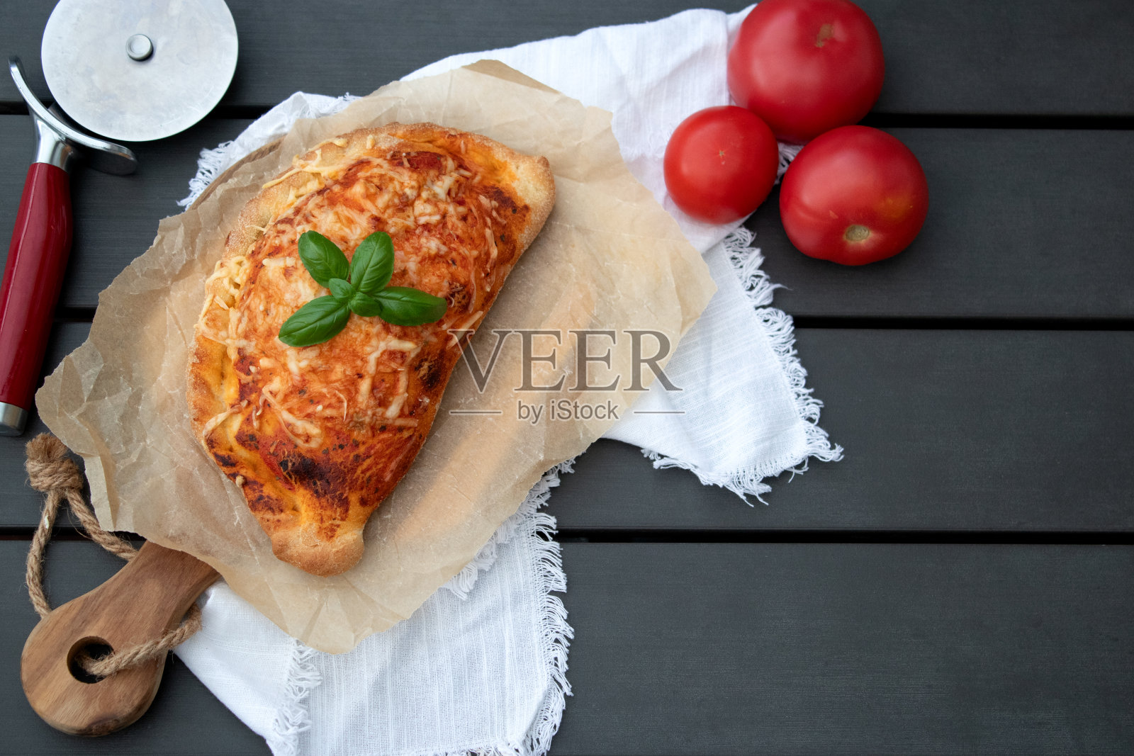 灰色的桌子上，木制盘子里有美味的披萨馅饼，配番茄酱和奶酪照片摄影图片