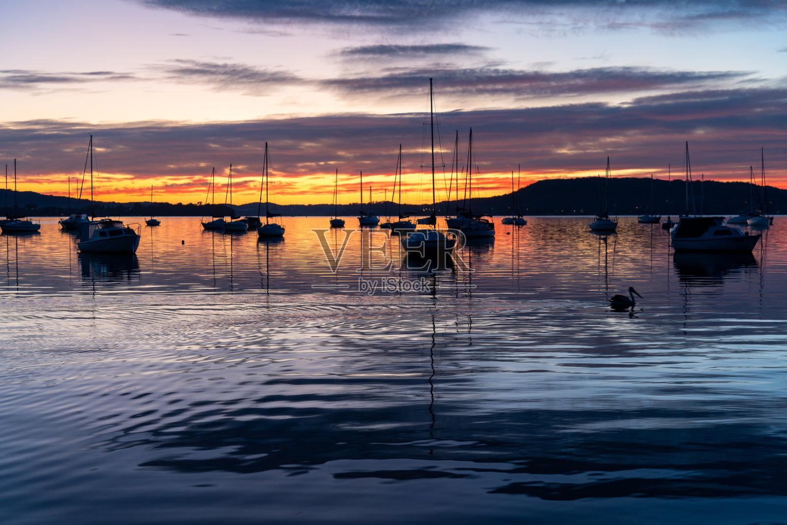 日出水面上有船，倒影和高云照片摄影图片