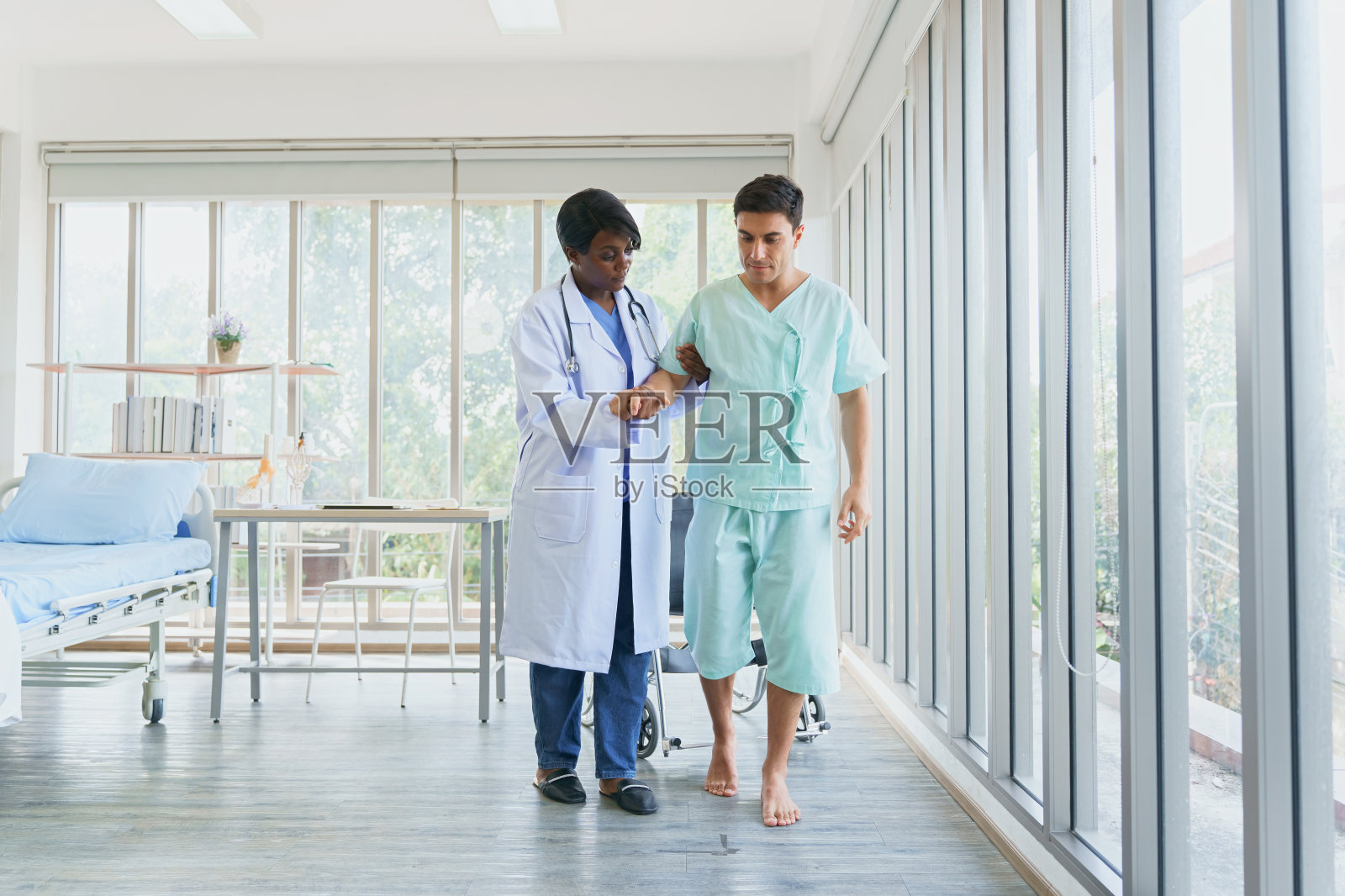 医生帮助病人学习走路训练。脊医做治疗，骨科做康复，治疗，康复让病人恢复正常。住院的物理治疗师和病人。照片摄影图片