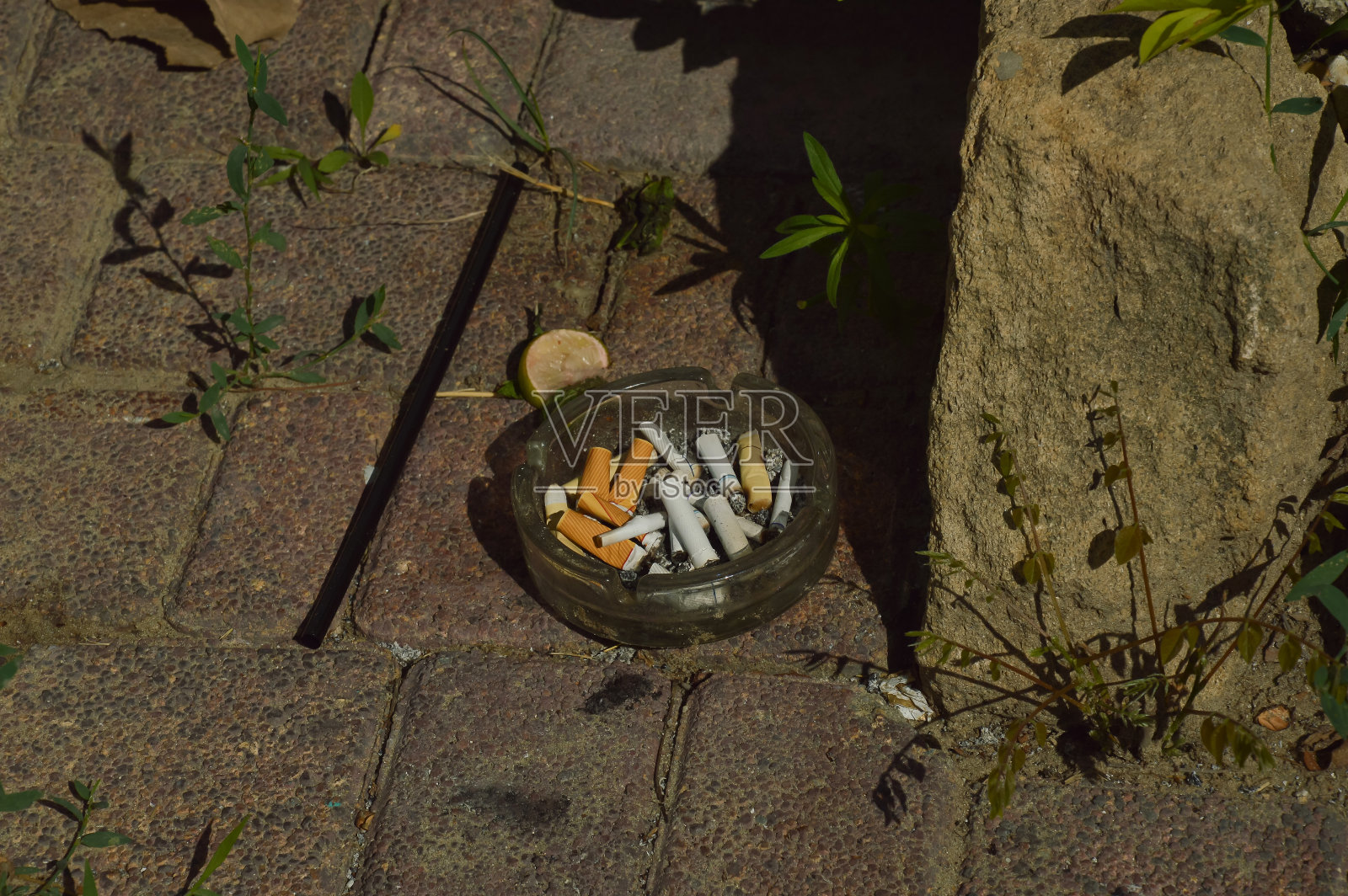 街上有烟灰缸和烟头，石头地板上。设计背景。垃圾照片摄影图片