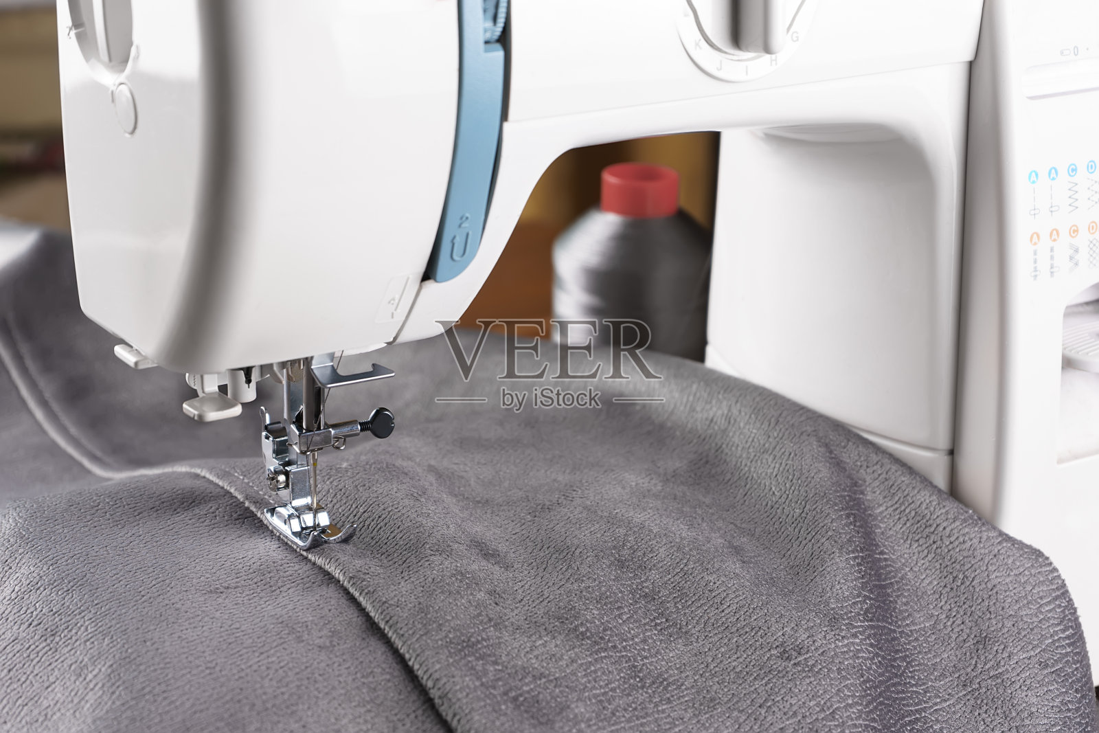 现代缝纫机与灰色丝绒织物近距离照片摄影图片