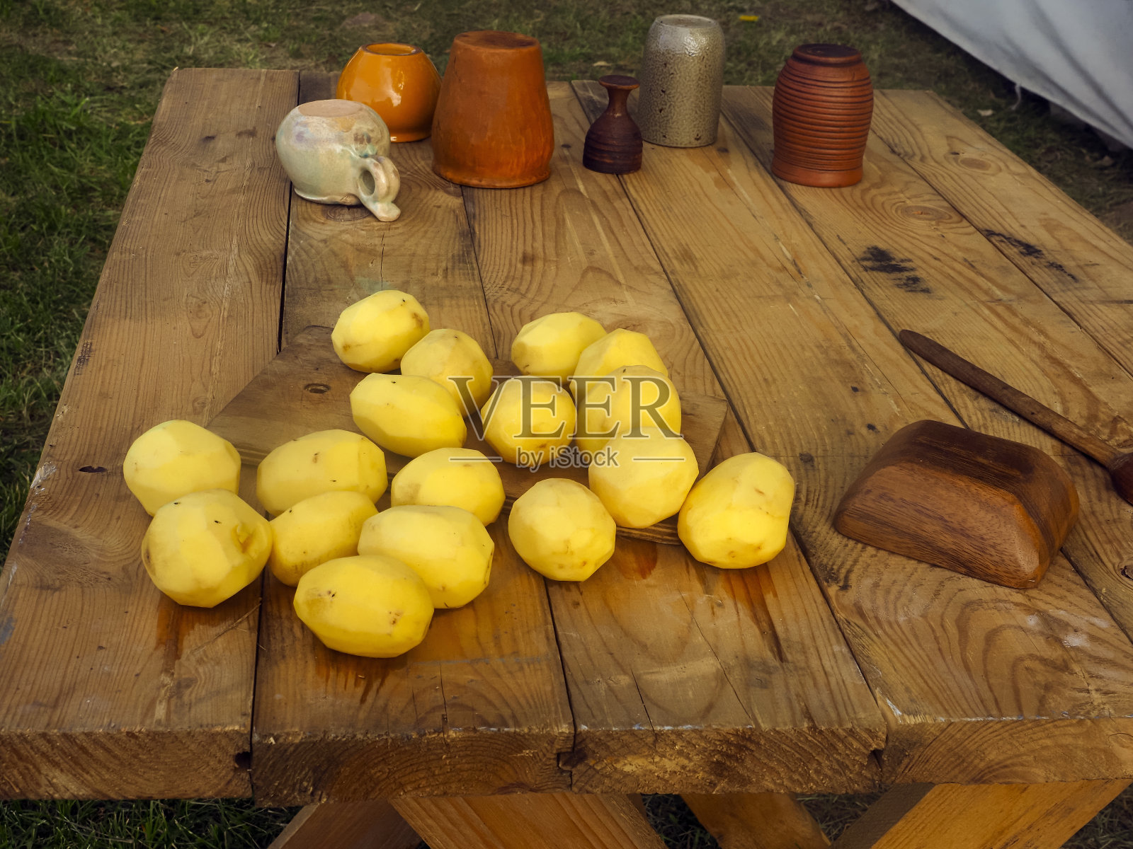 去皮的土豆放在户外的木桌上照片摄影图片