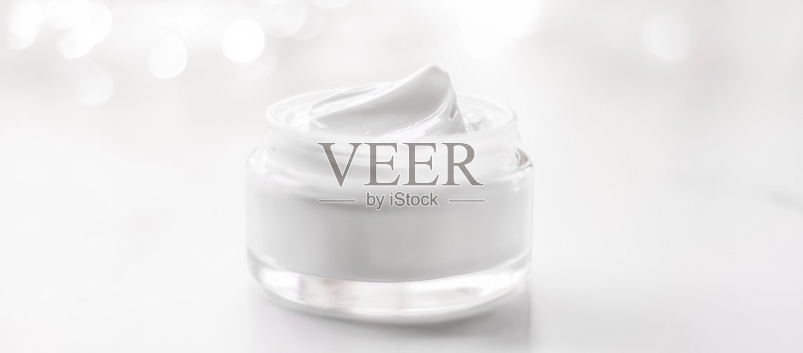 面霜保湿罐以假日亮片为背景，保湿护肤为提振乳液，抗衰老化妆品为奢华美容护肤品牌照片摄影图片