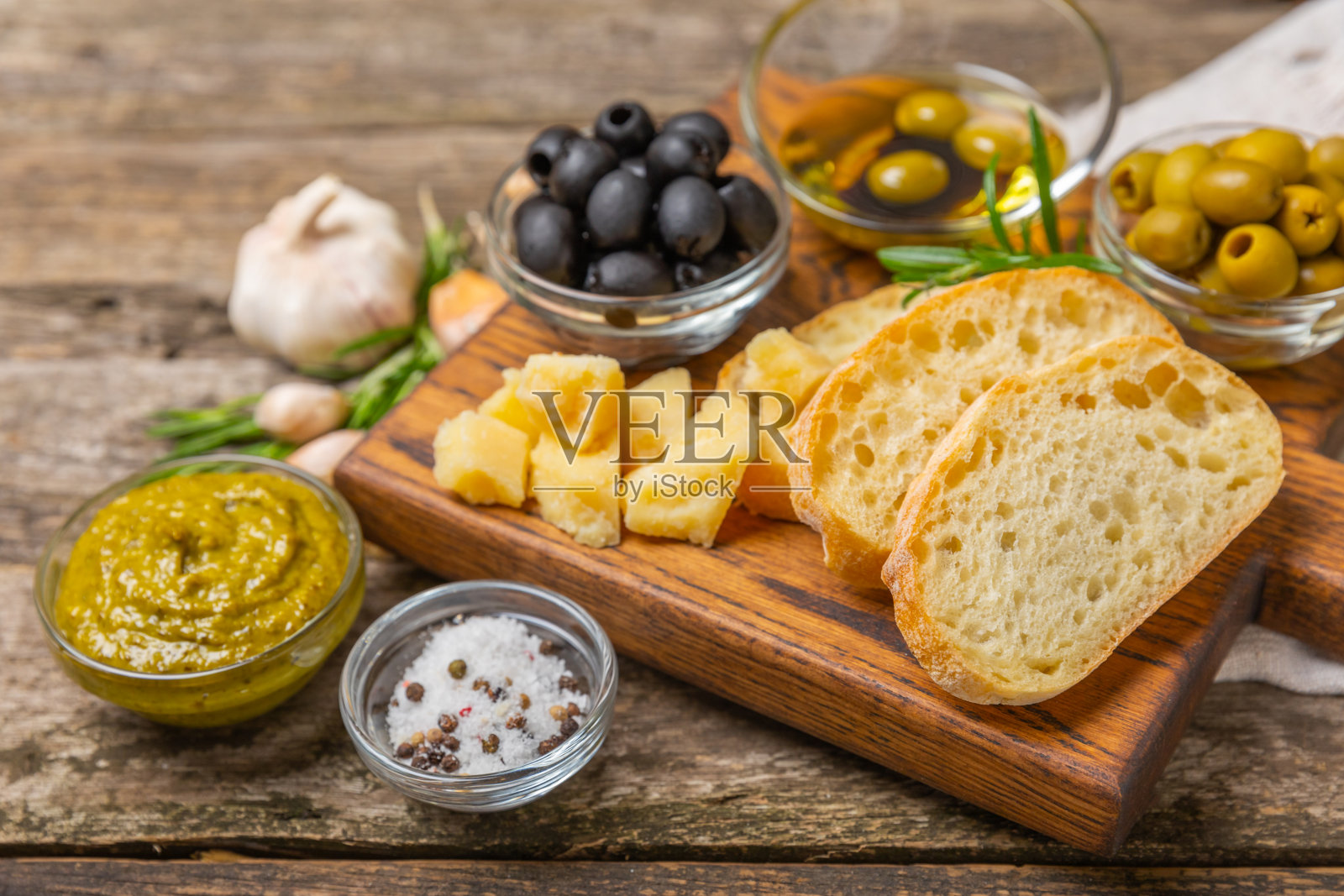 ciabatta，一碗橄榄油，配上橄榄、香草、香料、大蒜、香蒜酱、帕尔马干酪和ciabatta面包。健康食品理念，美味。地中海厨房。副本的空间。照片摄影图片